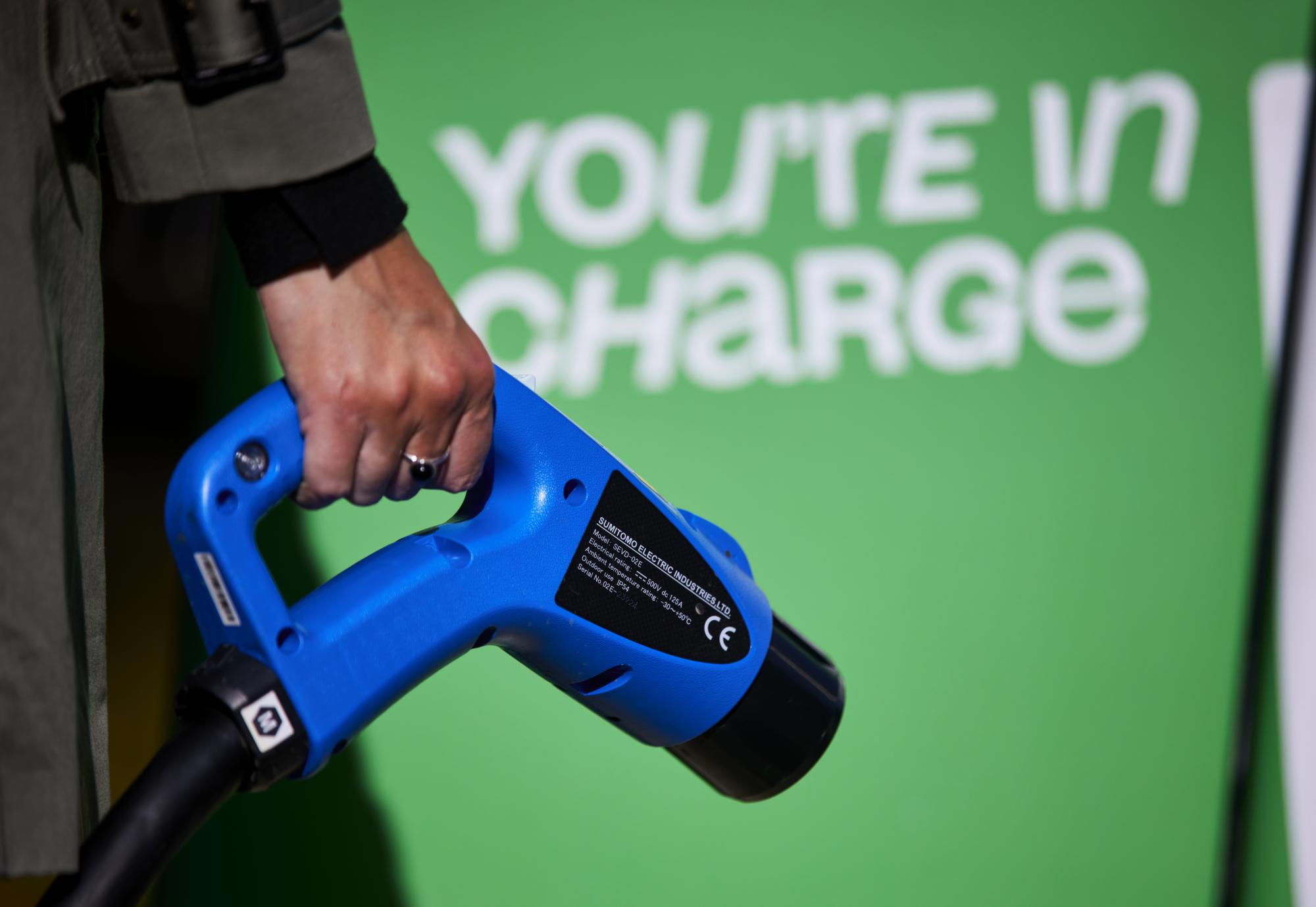 Woman holding an electric vehicle charger