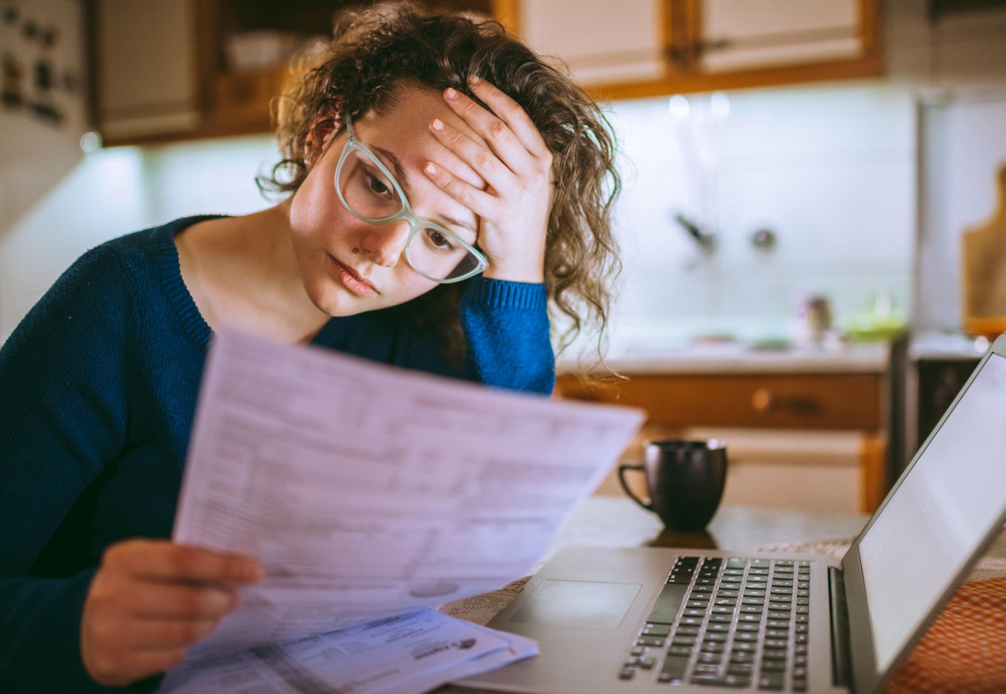 Young woman looking upset at her bill