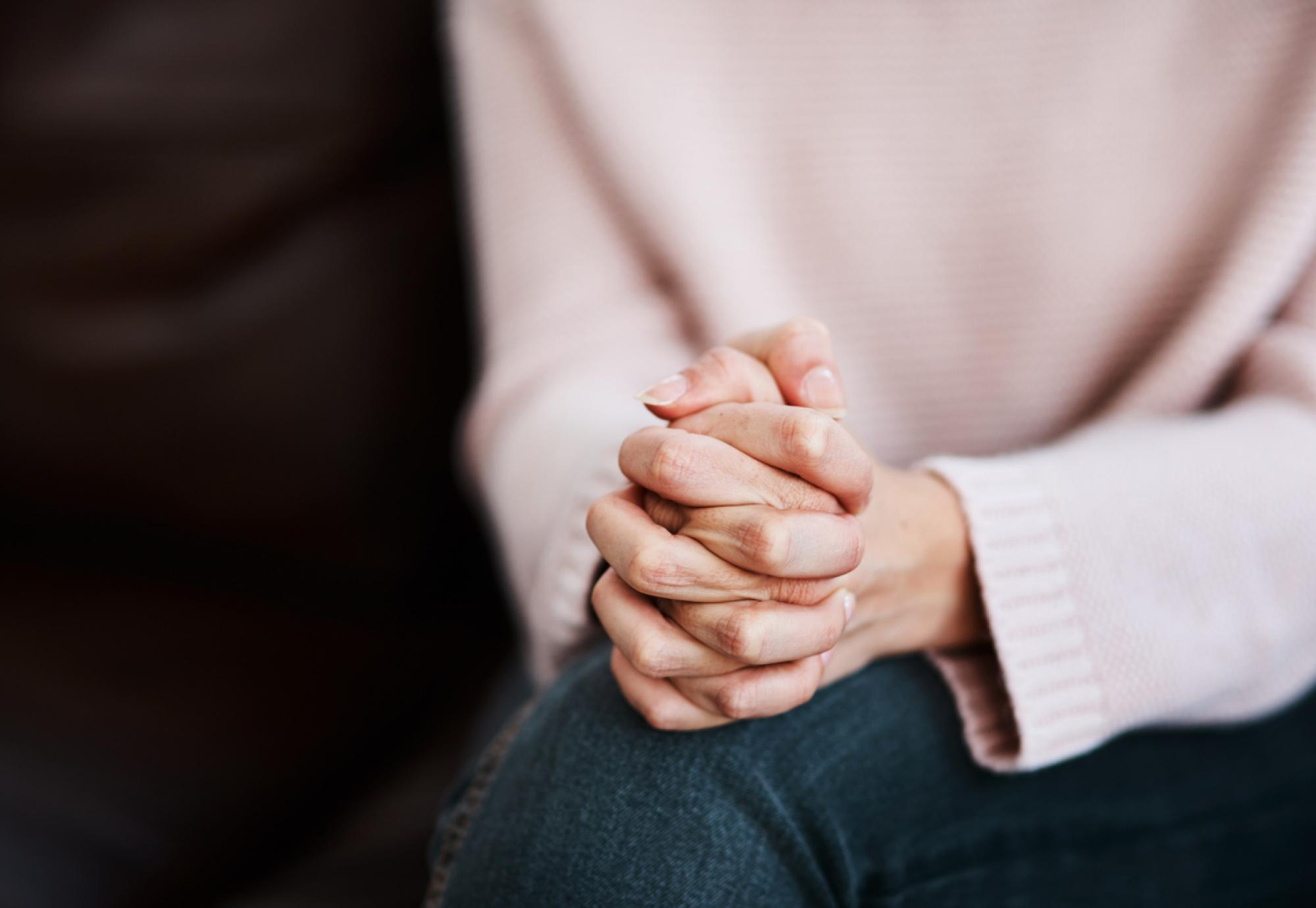 Cropped shot of a woman sitting on a sofa and feeling anxious