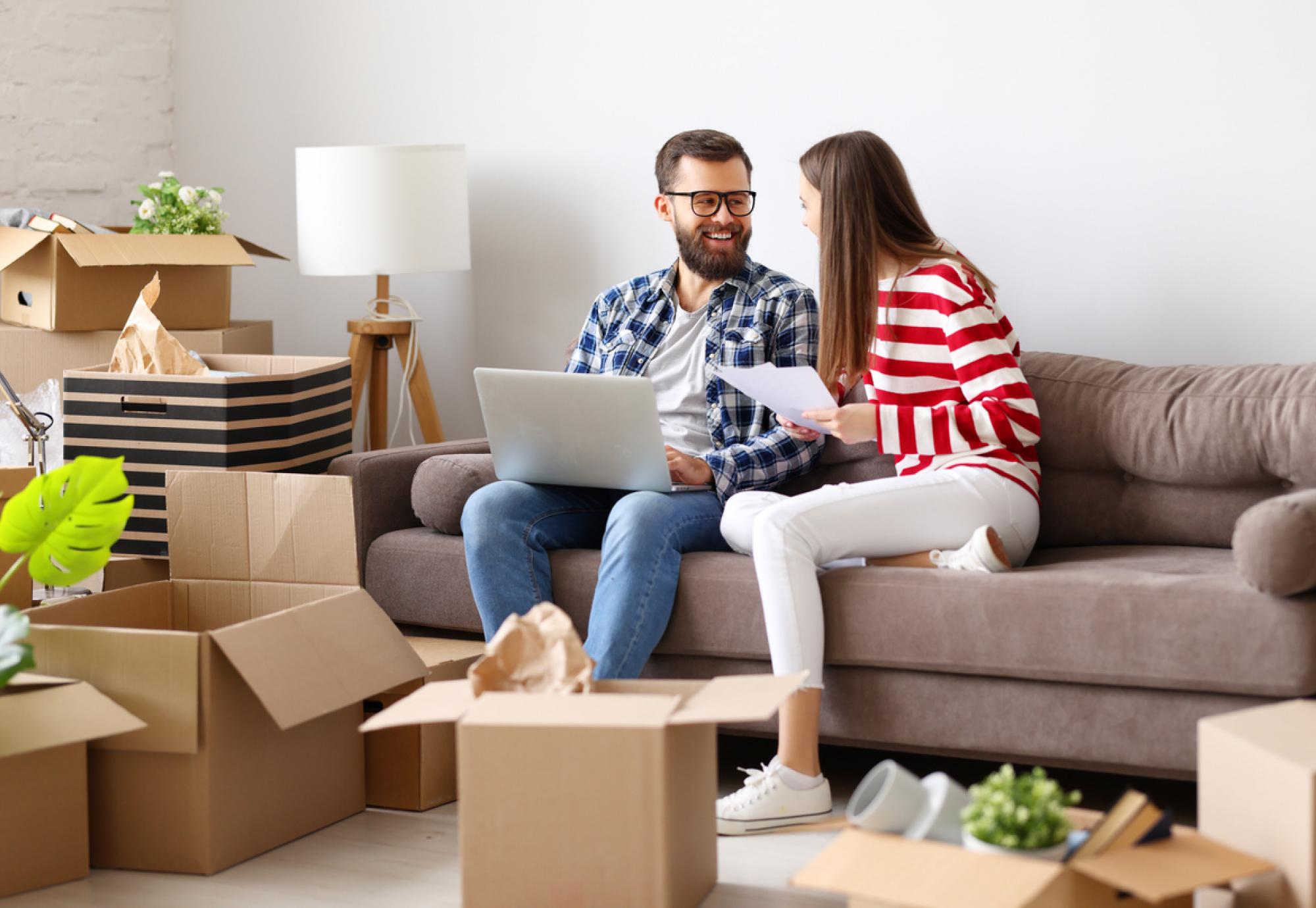 Couple in room full of boxes after moving into their first home