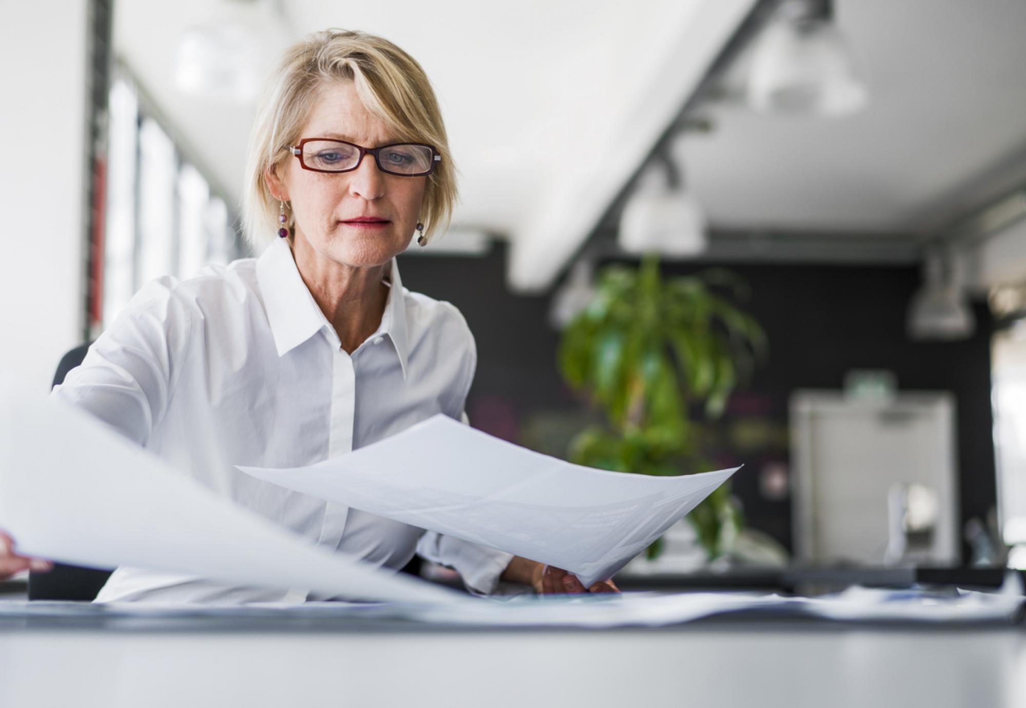 woman looking at sheets of paper