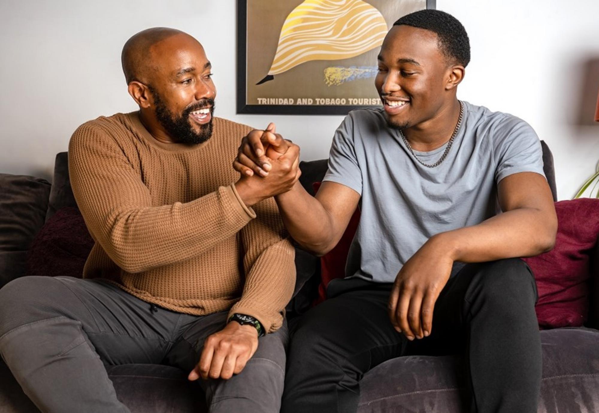 Two young men sat on a sofa