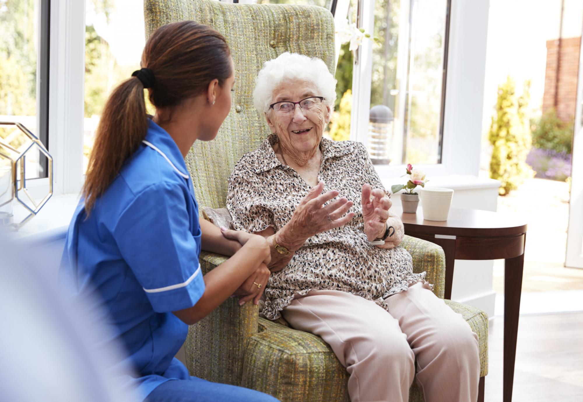 Elderly lady sat with carer