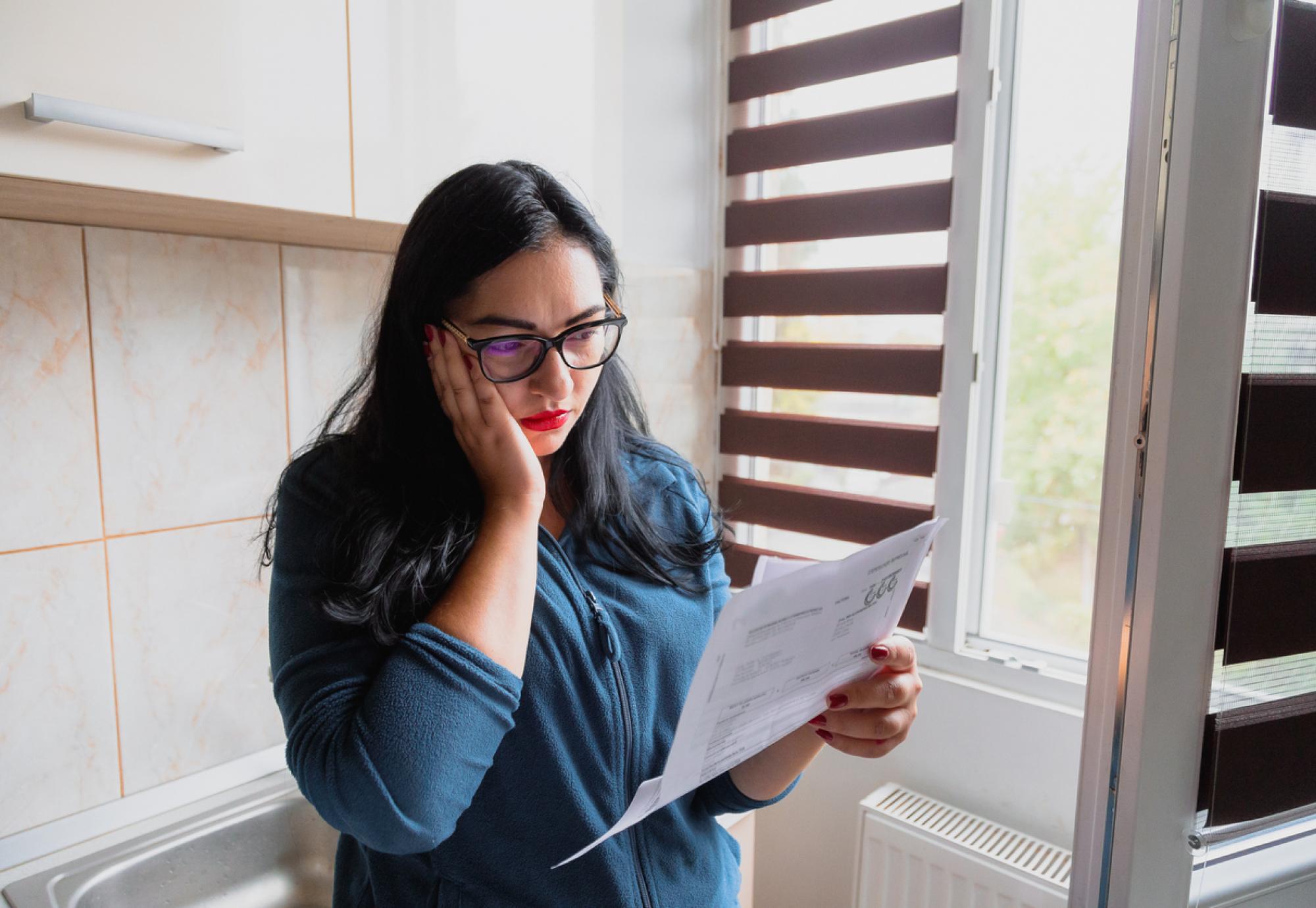 Portrait of a mid adult woman checking her energy bills at home