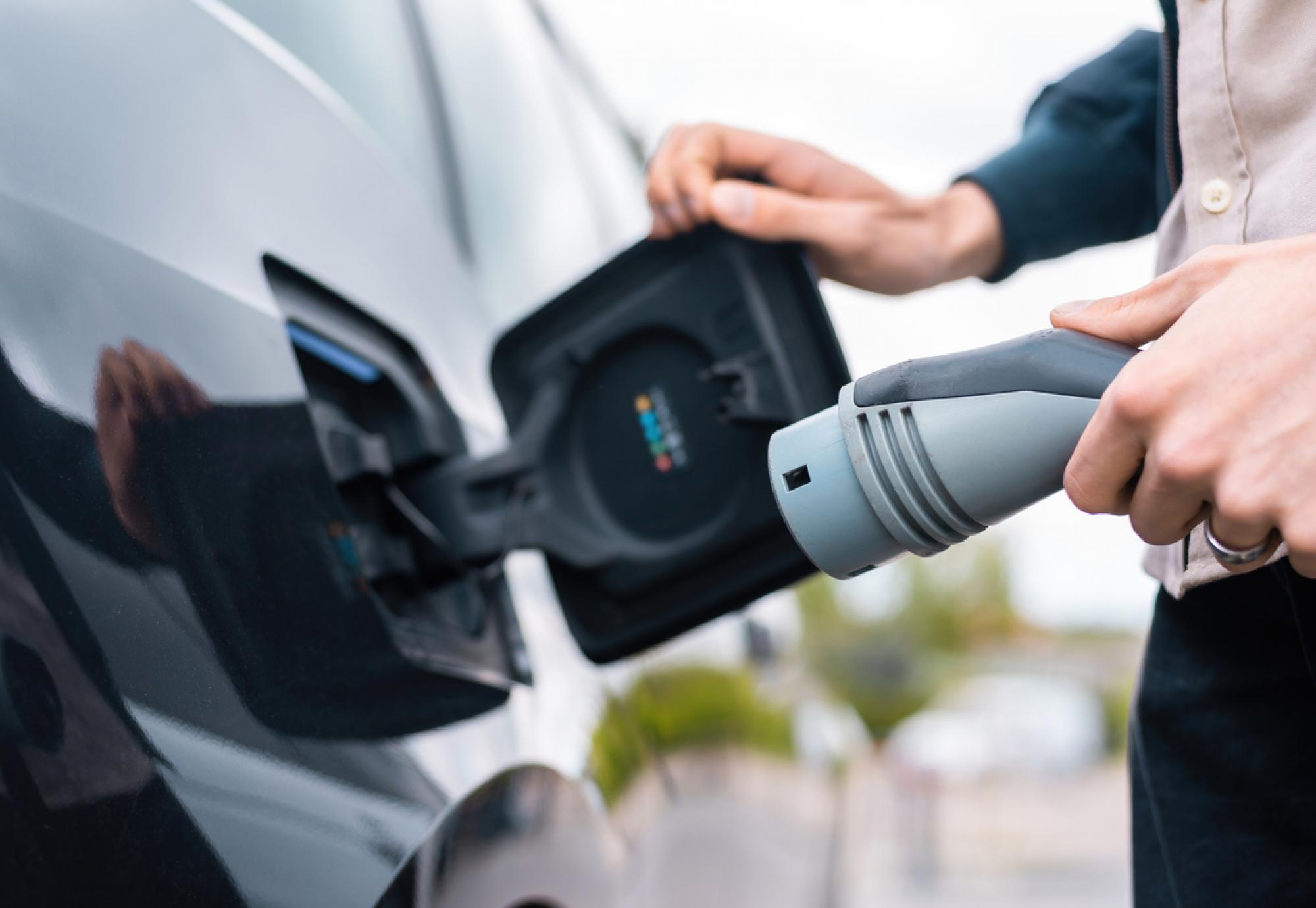 Man using electric vehicle charger