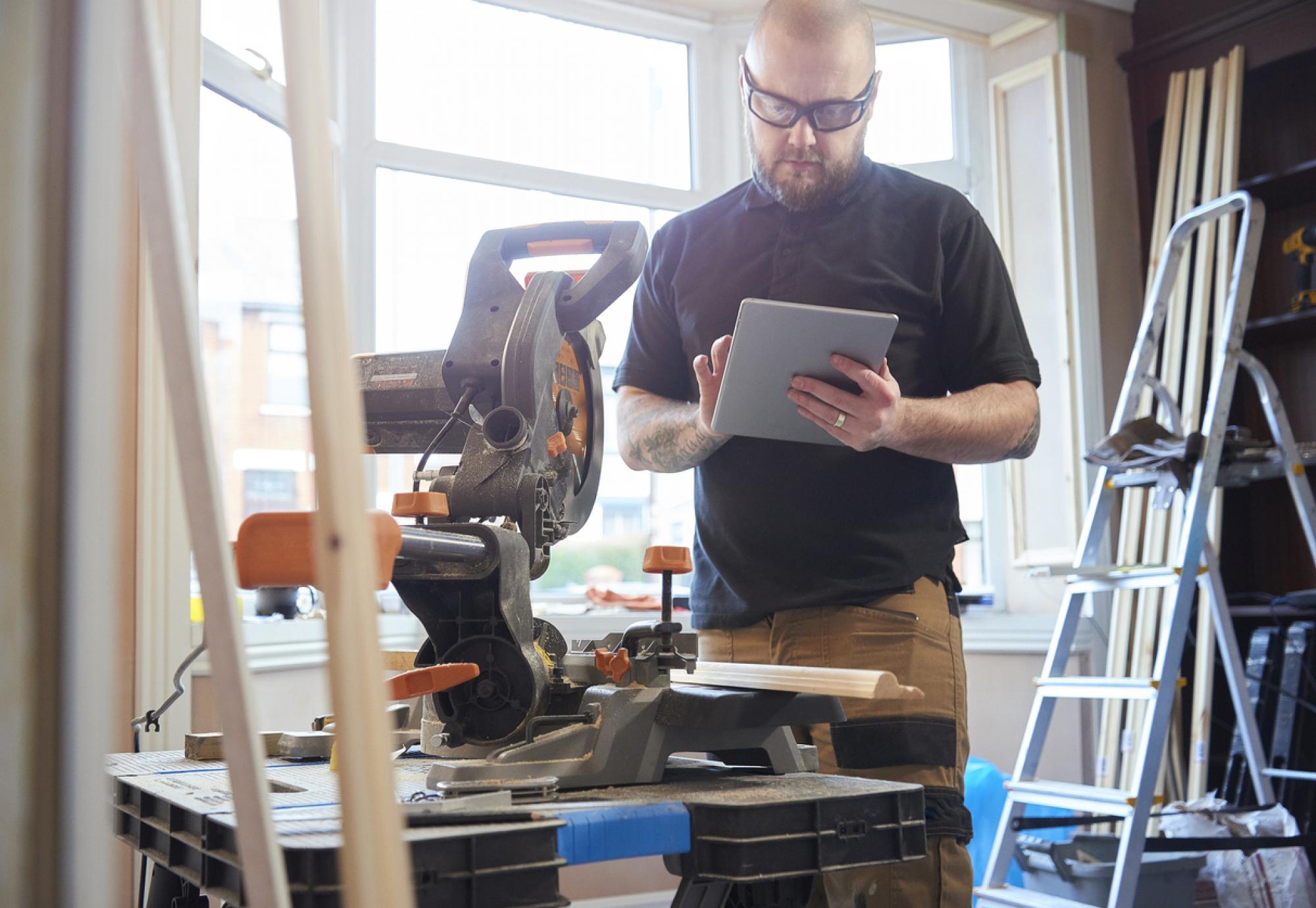 Self-employed person working on a tablet. Tradesman.