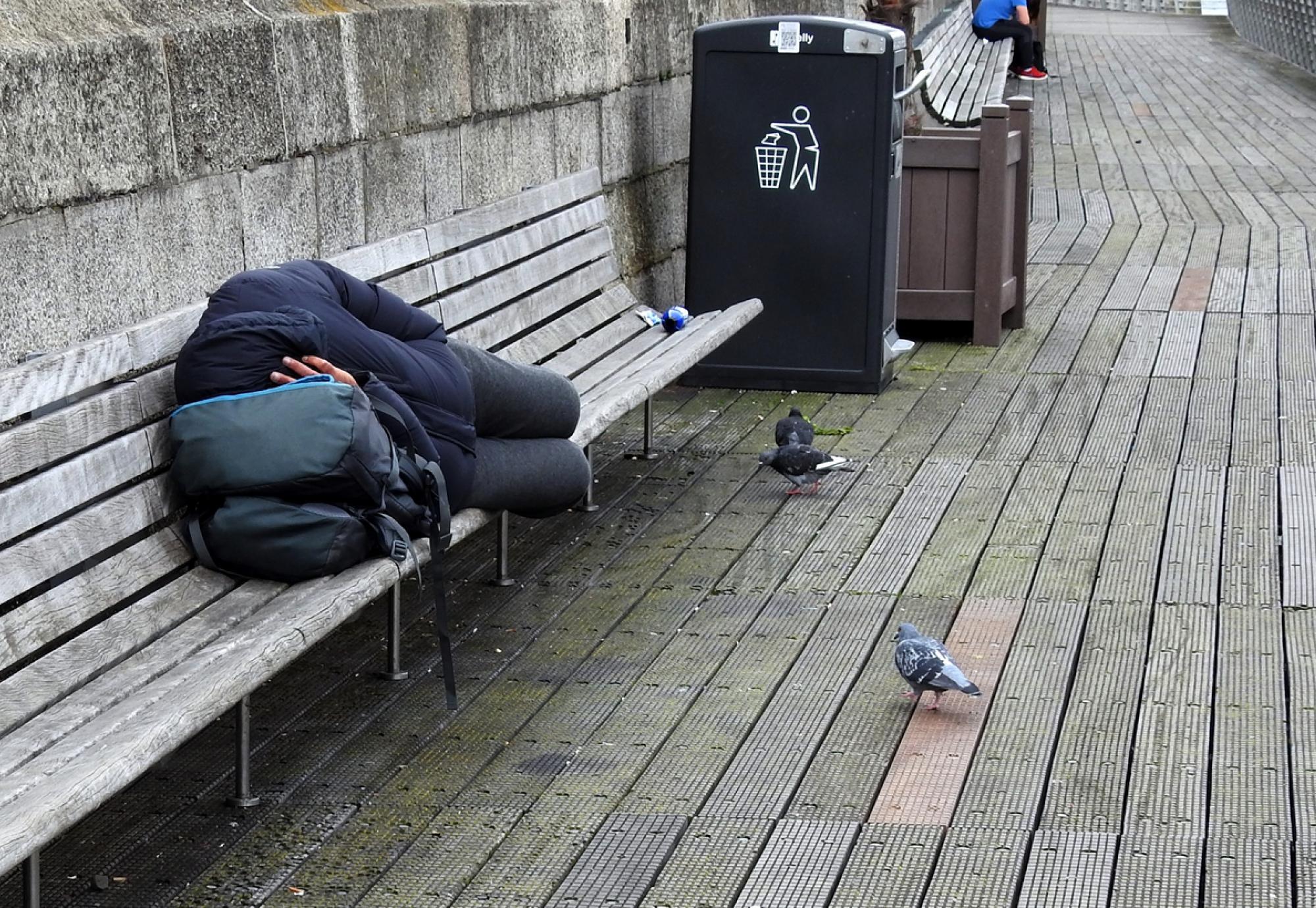 Homeless man sleeping on a bench