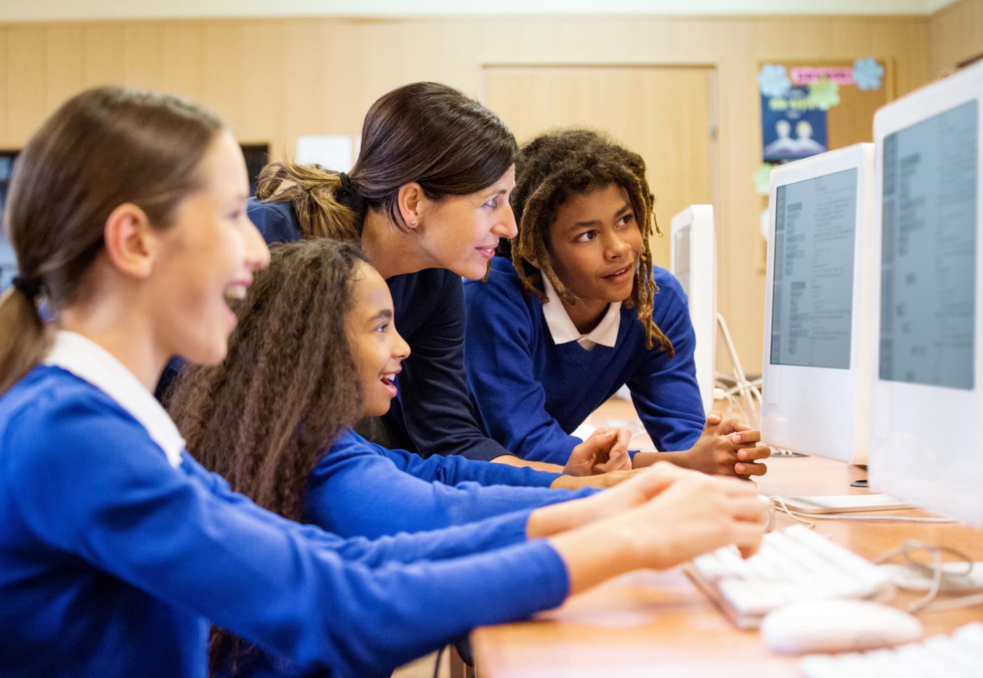 School children gathered round a computer