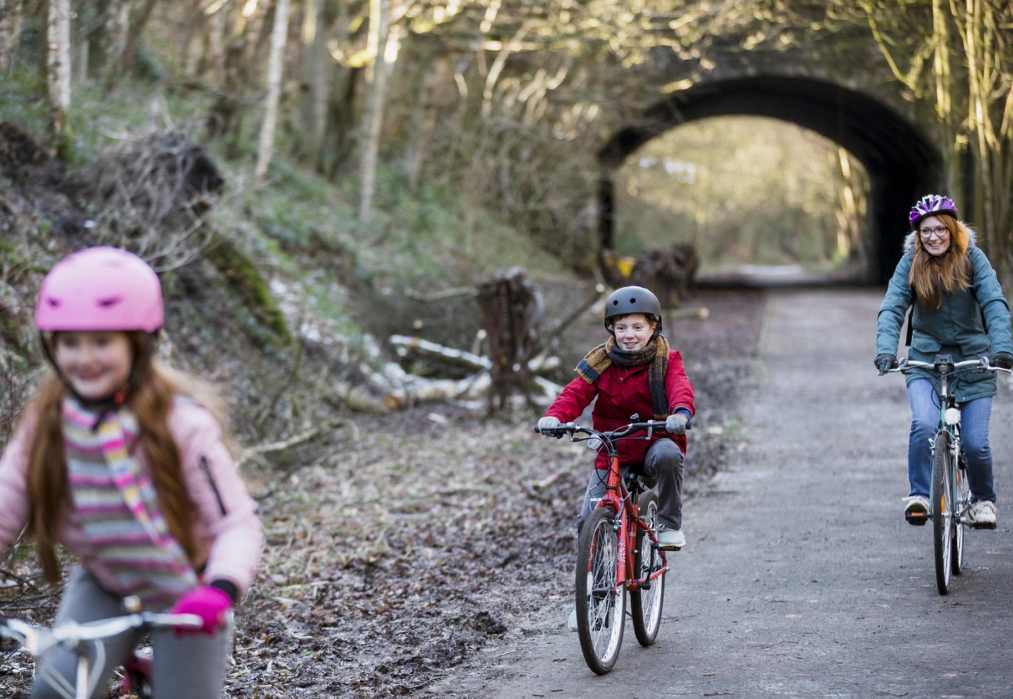 A family cycling through a park