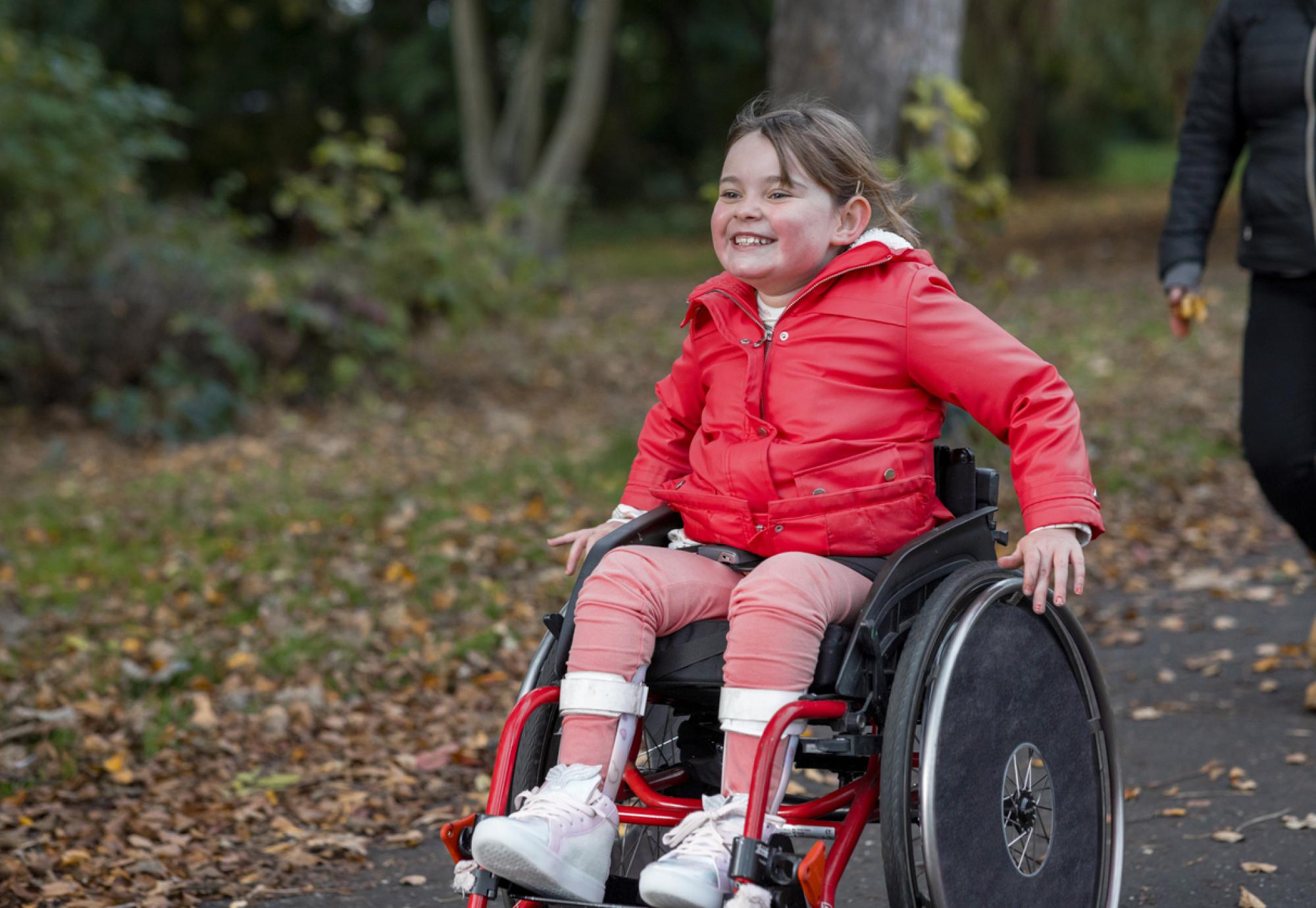 Picture of a young girl in a wheelchair in a public park