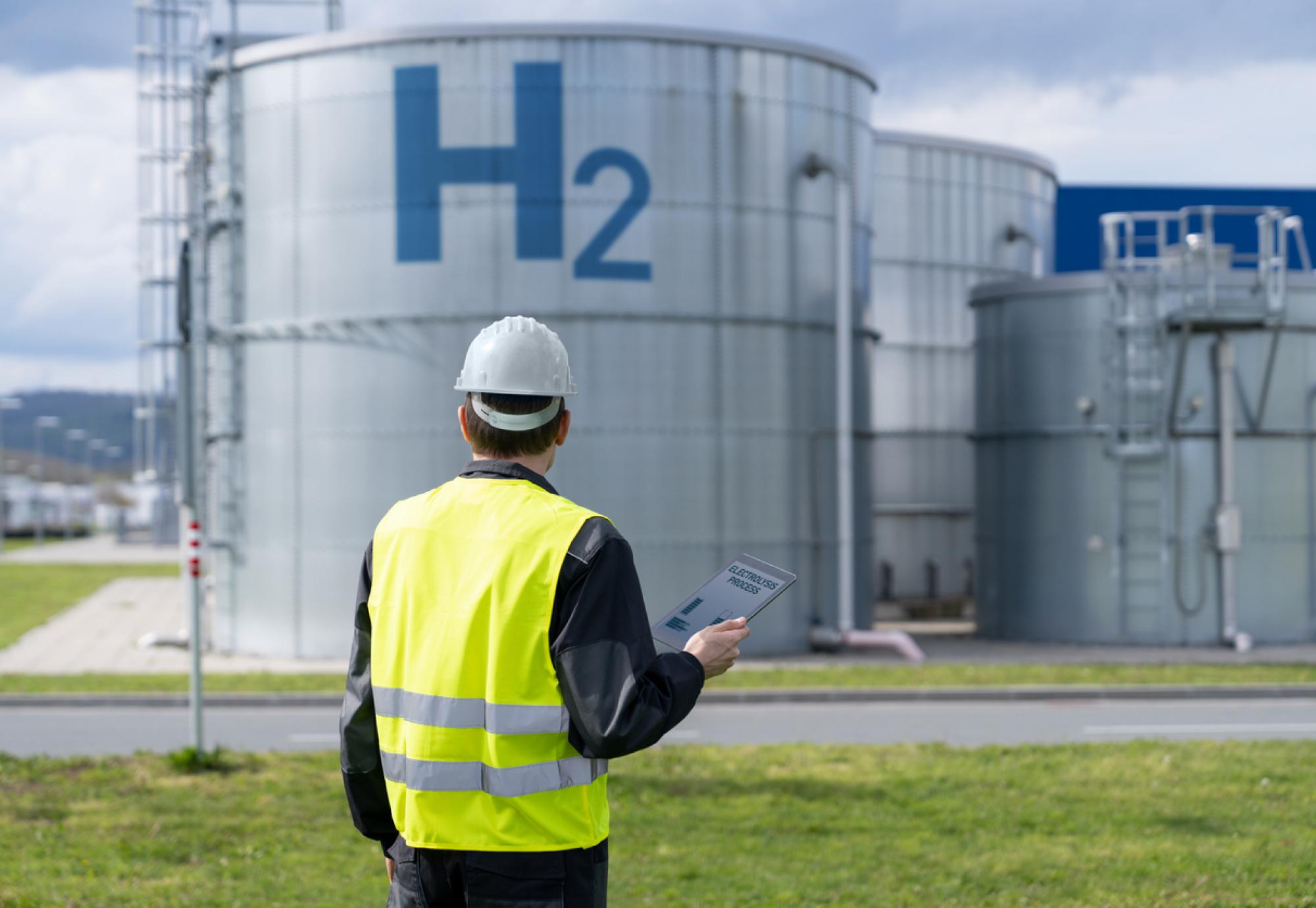 Man in hi vis in front of a hydrogen storage tank