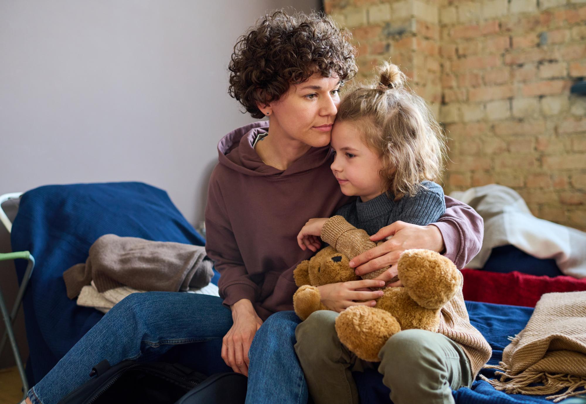 Homeless mother and daughter cuddling