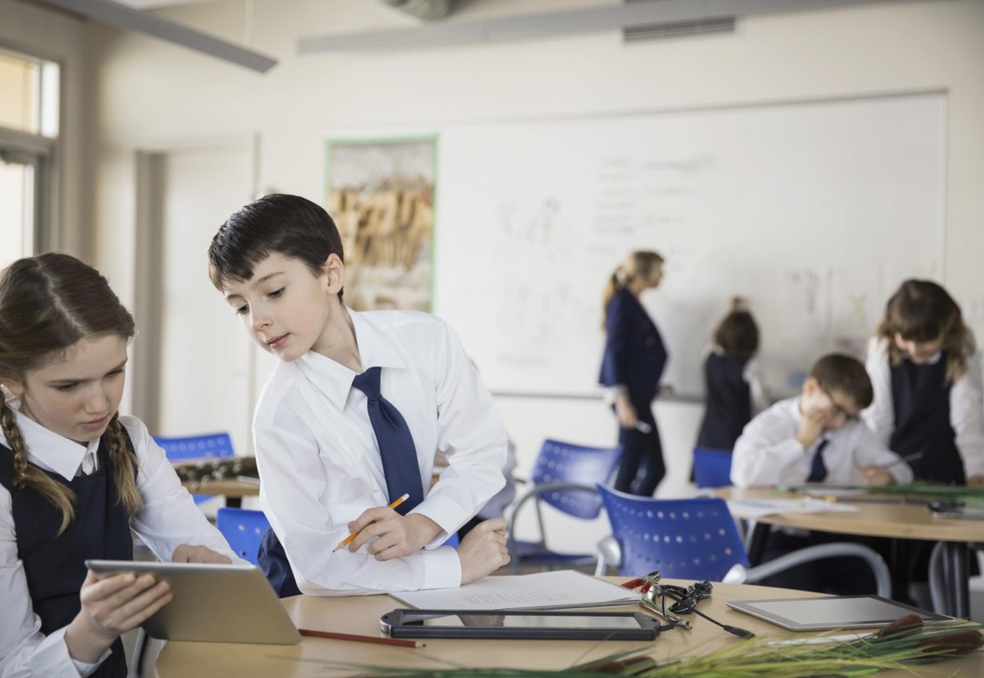 Two schoolchildren using an iPad