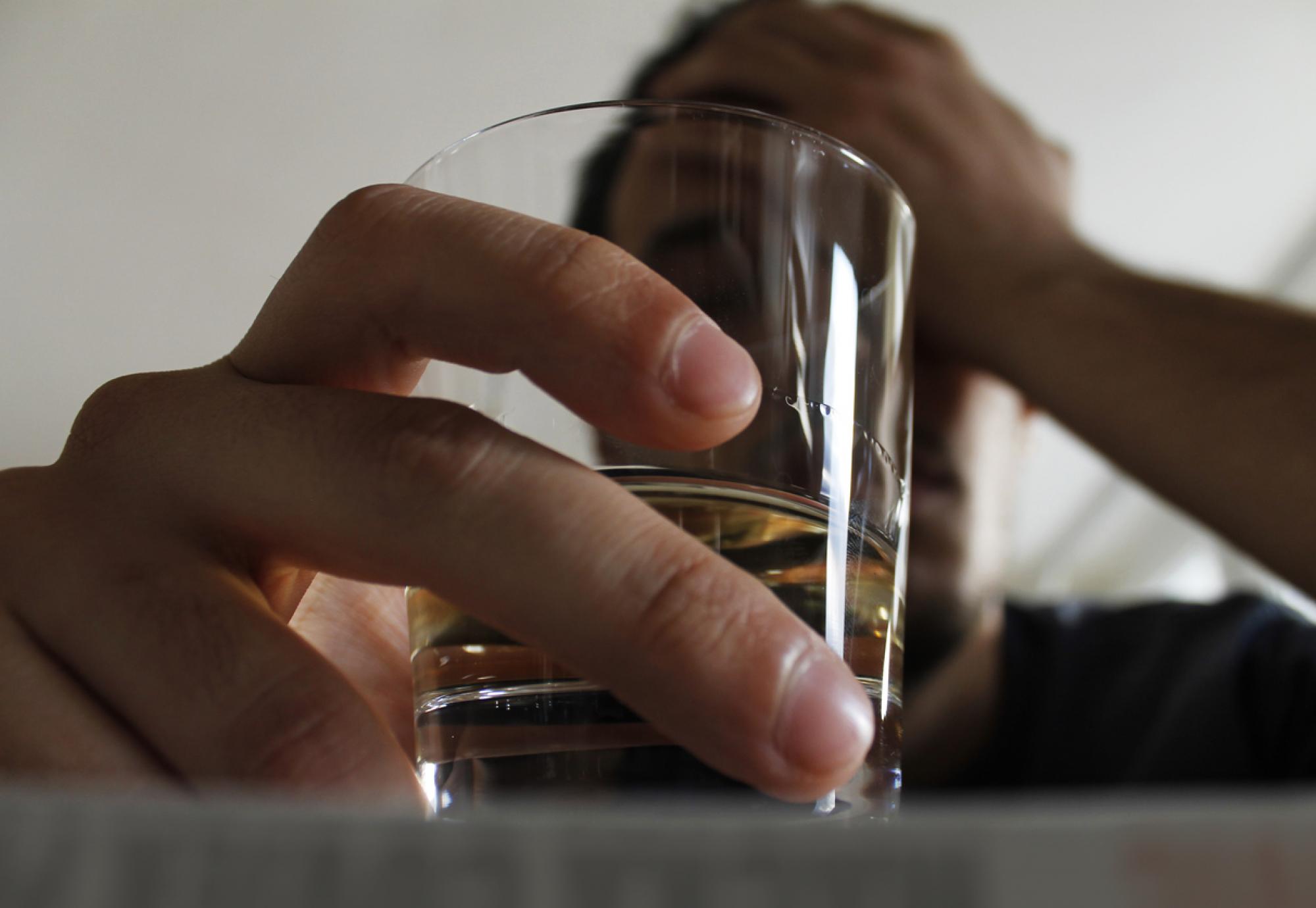 Man holding class of alcohol