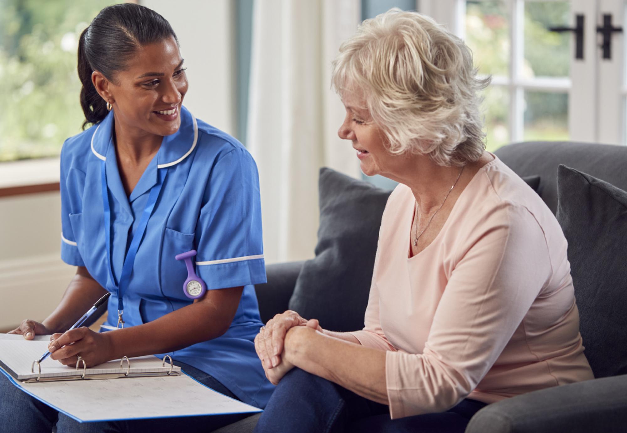 Social care worker sat with an older woman