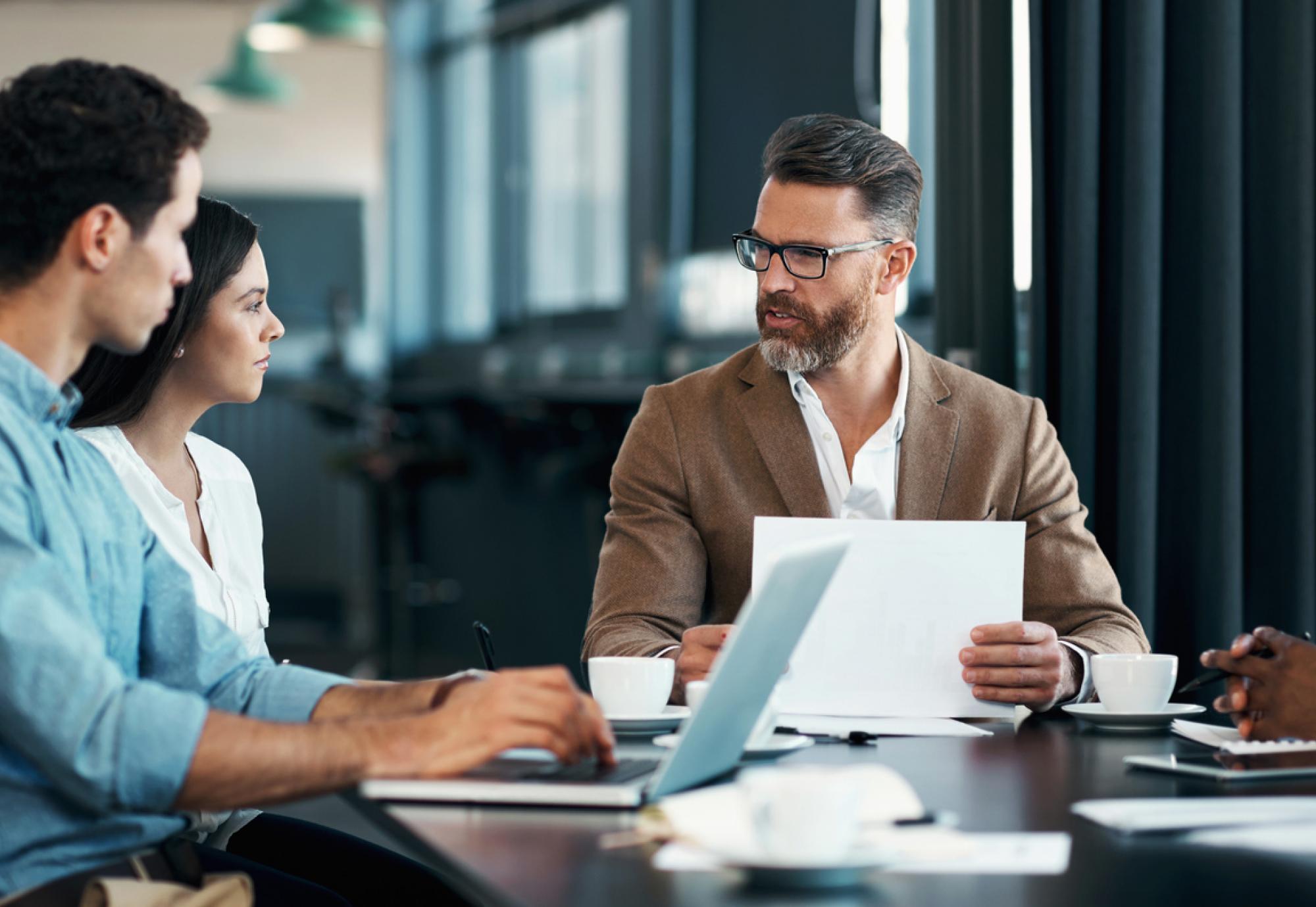 Man with beard talking with colleagues