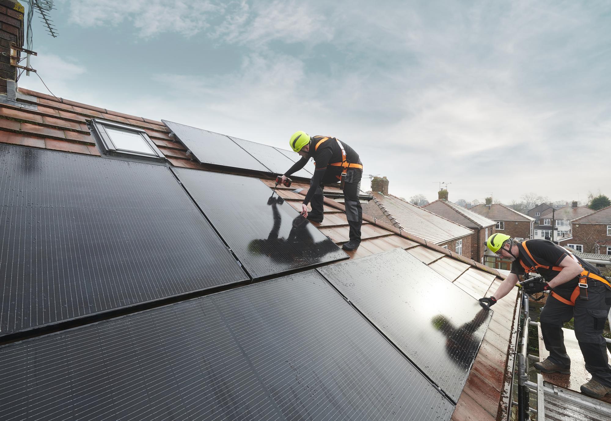 Men installing solar panels, a source of green energy