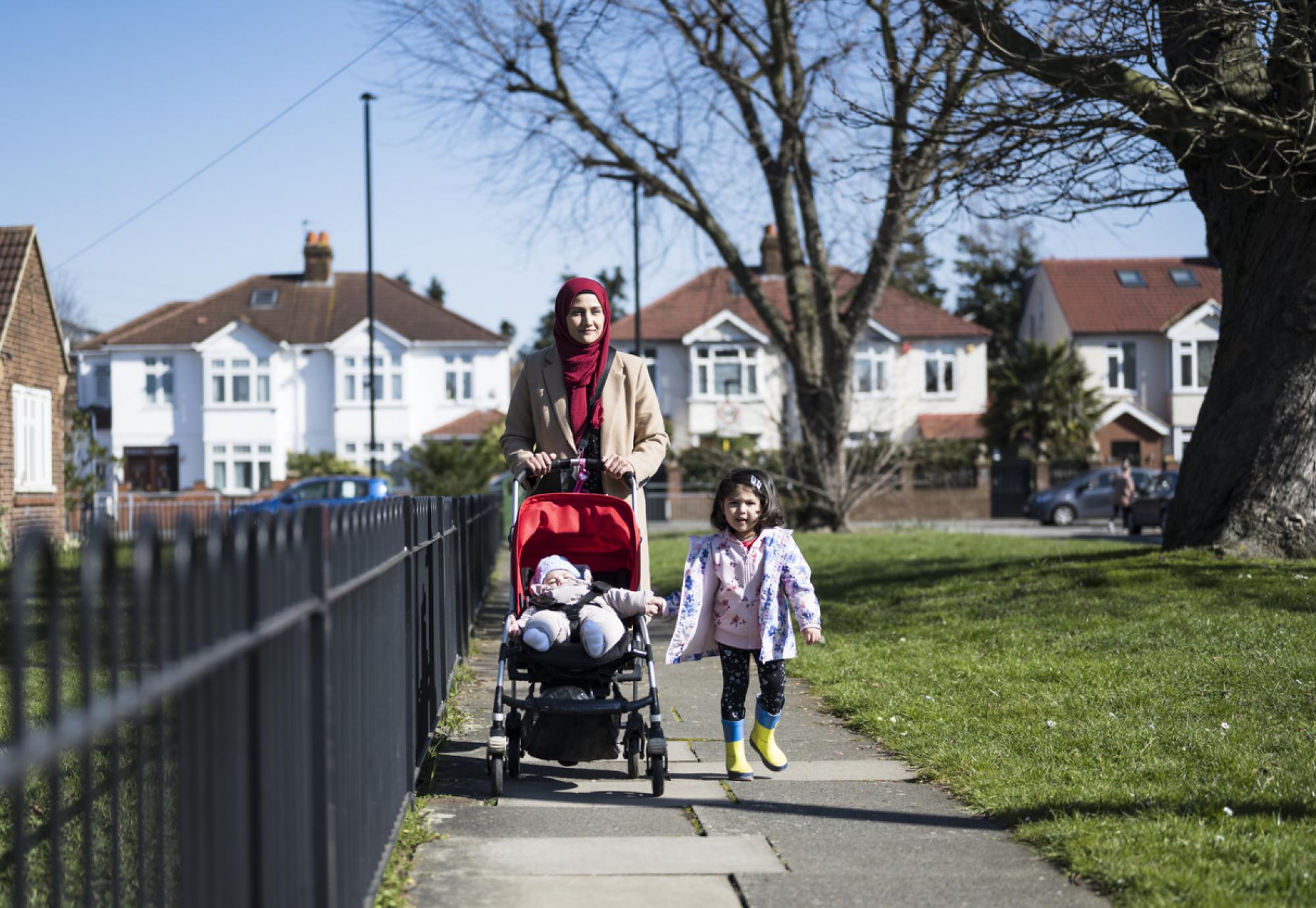 Woman and daughter walking through Hounslow on a sunny day