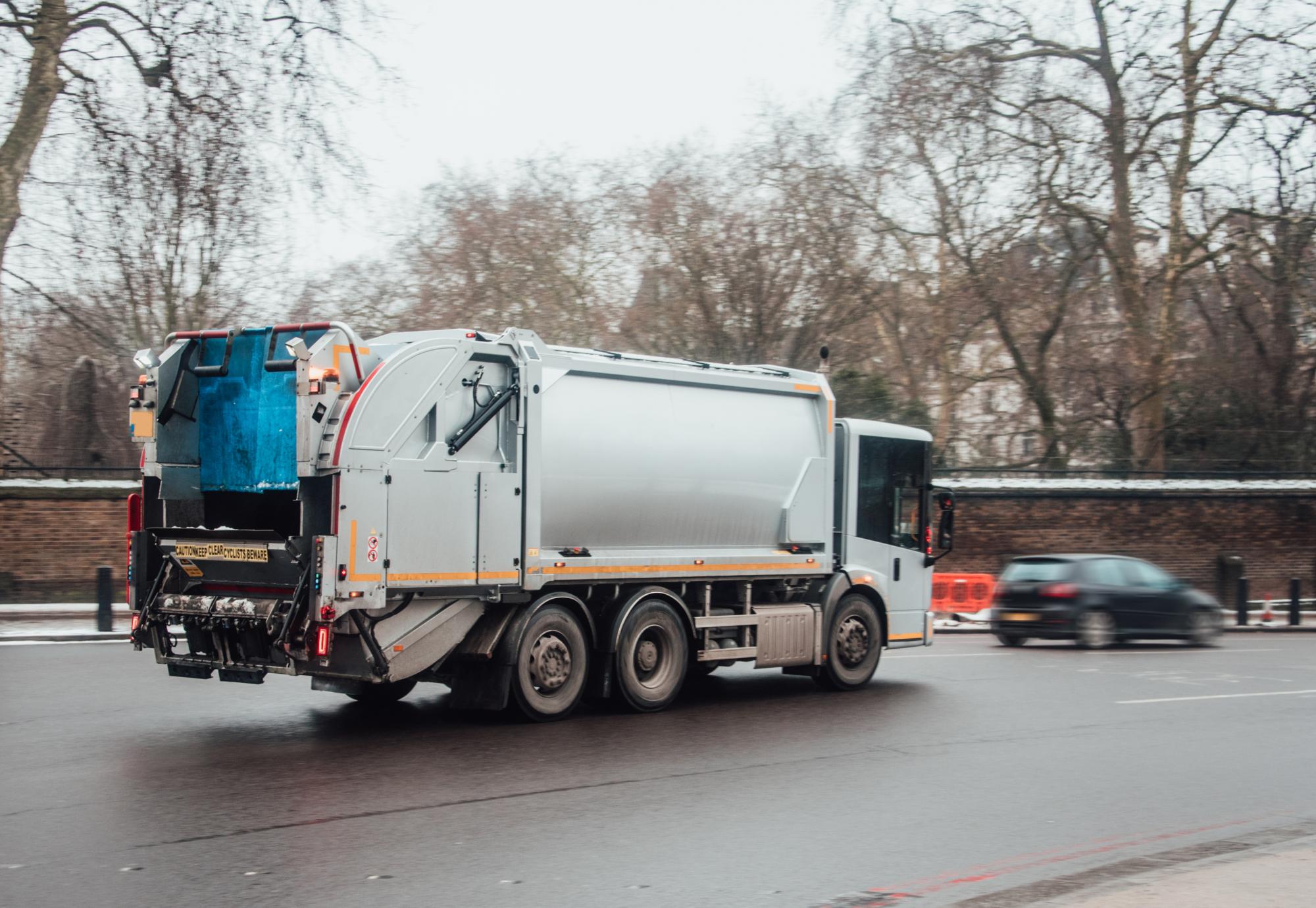 A garbage truck in the middle of a city