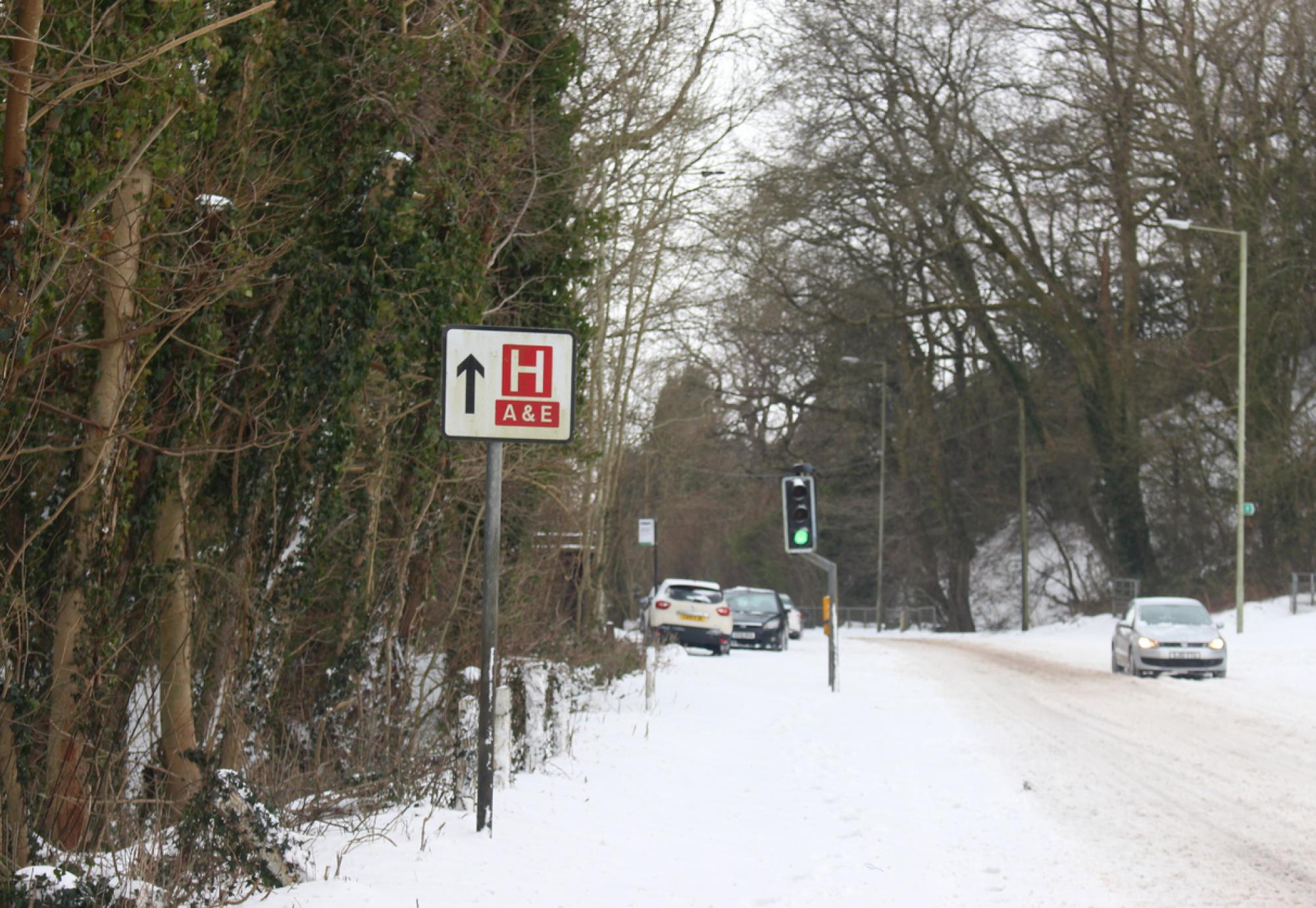 A sign for a hospital on a snowy road