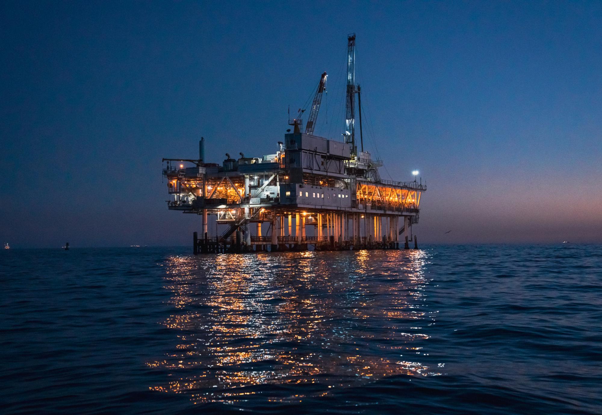 Night Time Offshore Oil Rig Drilling and Fracking Operation, Brightly Lit, on Calm Seas, Oil Platform