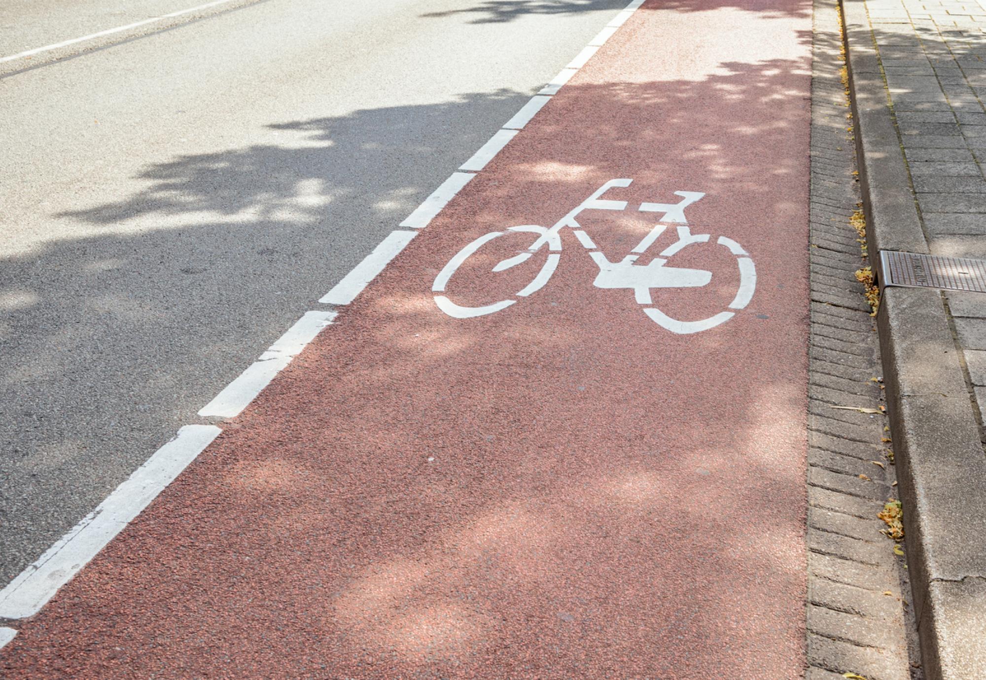 Red bicycle lane along a street in a city centre