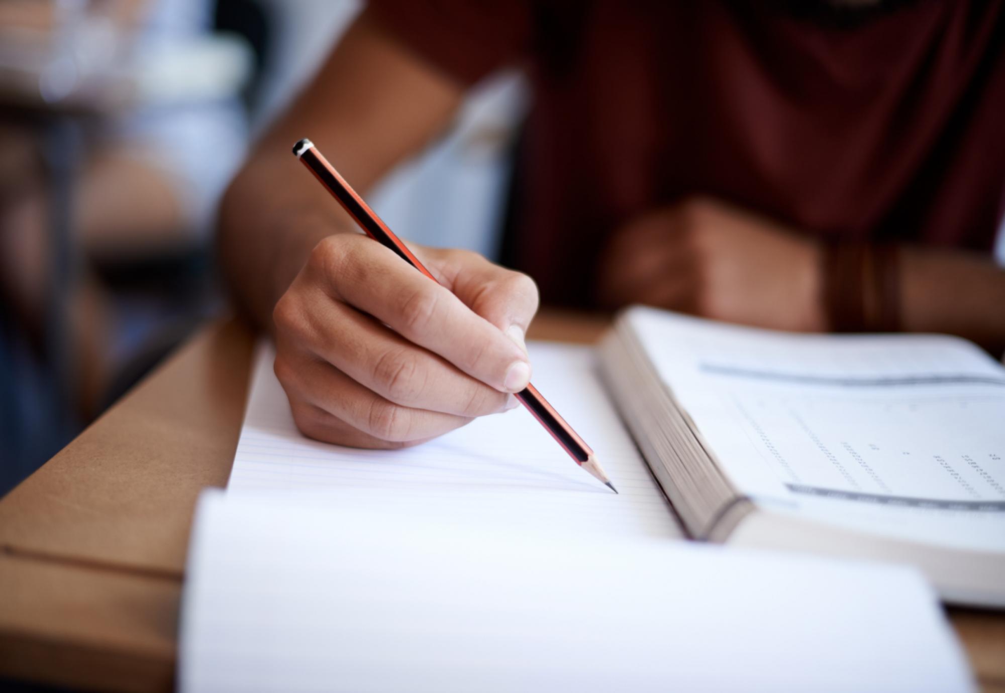 Closeup shot of an ex-offender writing on a note pad