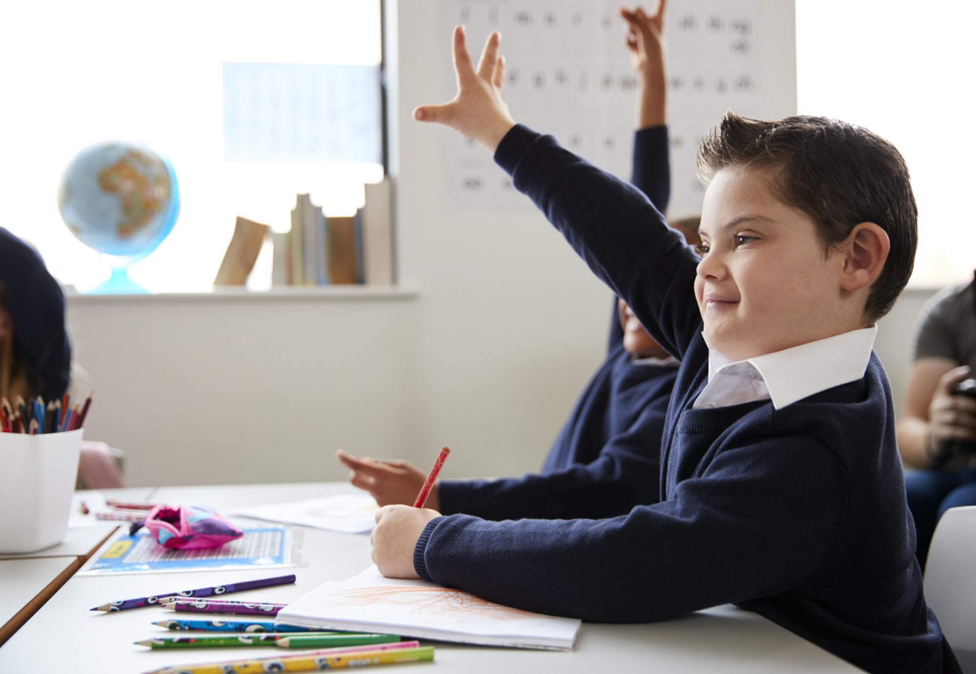 Schoolboy with Down syndrome sitting at a desk