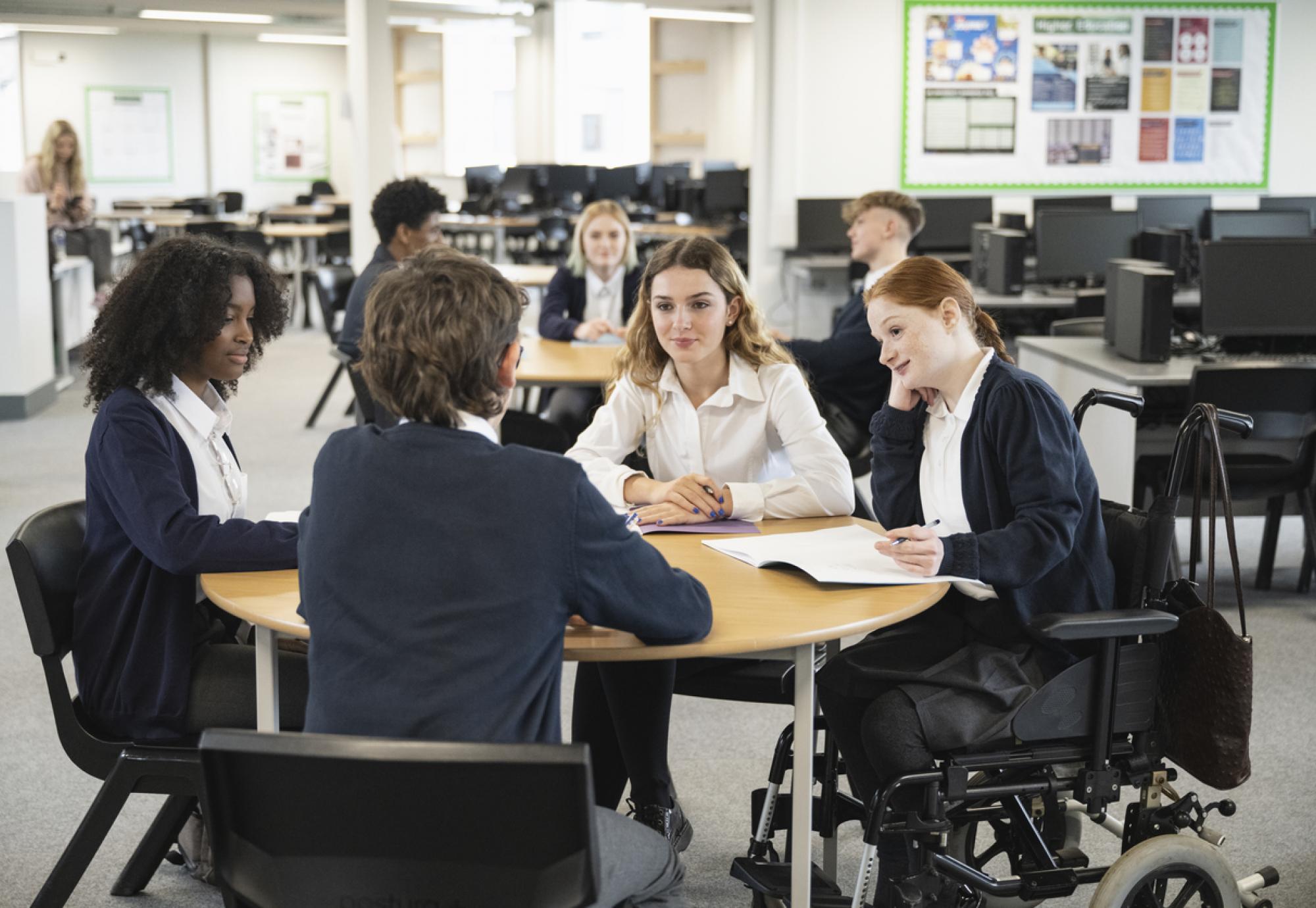Teenage students interacting in collaborative workspace