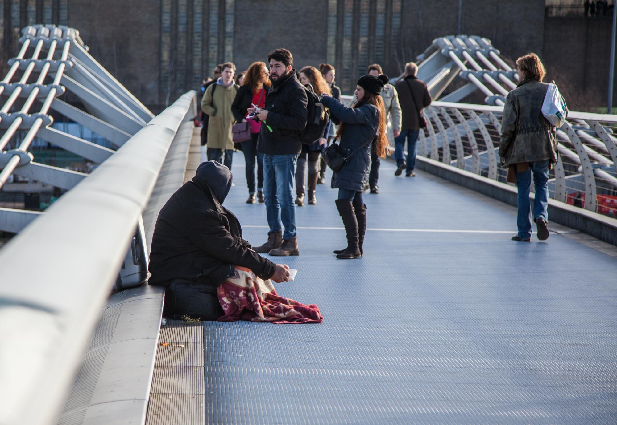 homeless man sat on a bridge in London