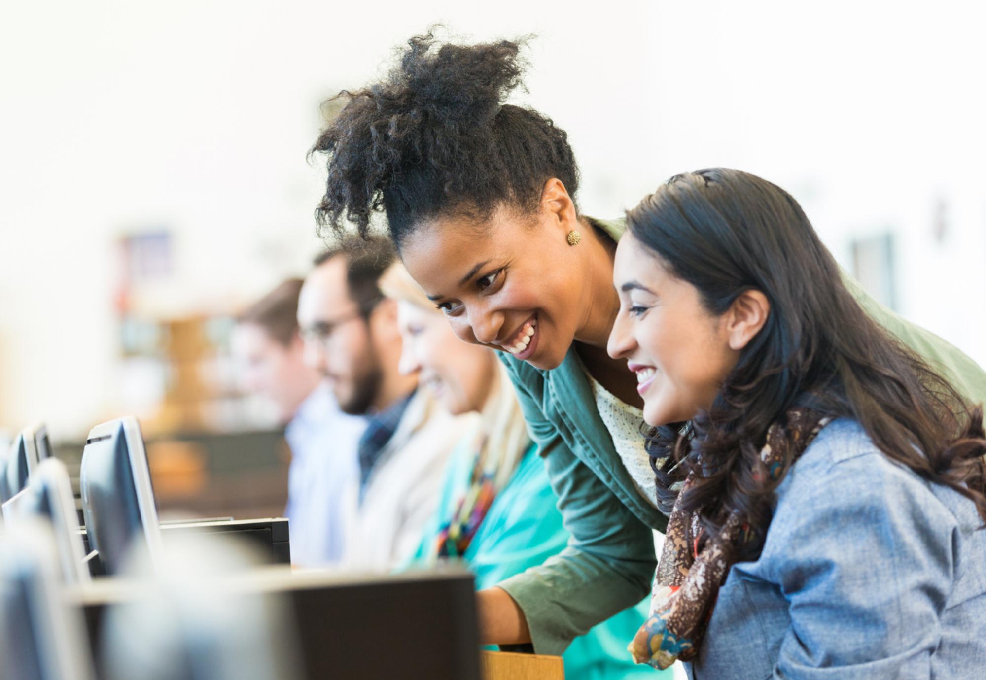 Diverse mid adult students using computers during class in college