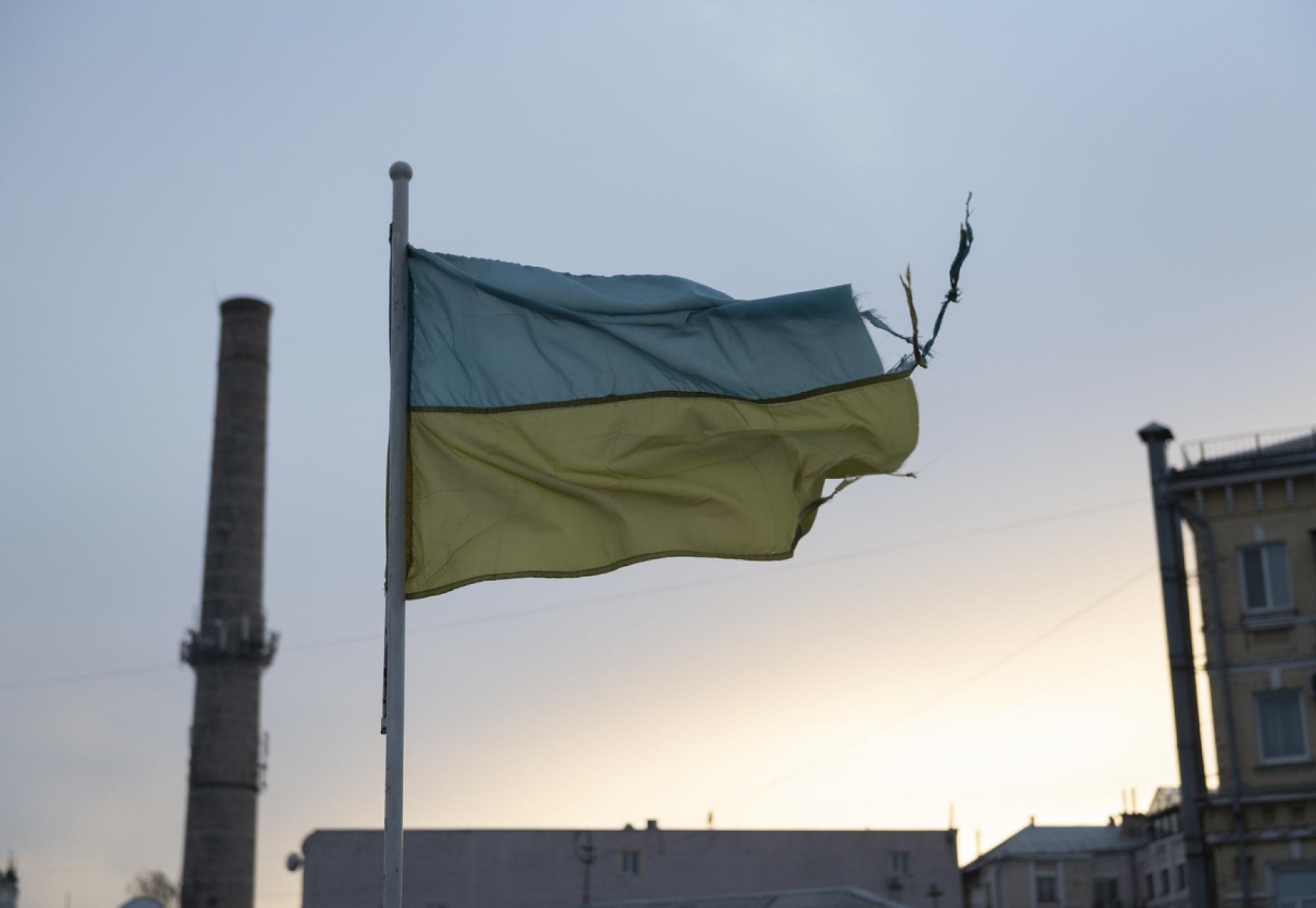 weathered Ukrainian flag flies in the Podil district of Kyiv, Ukraine