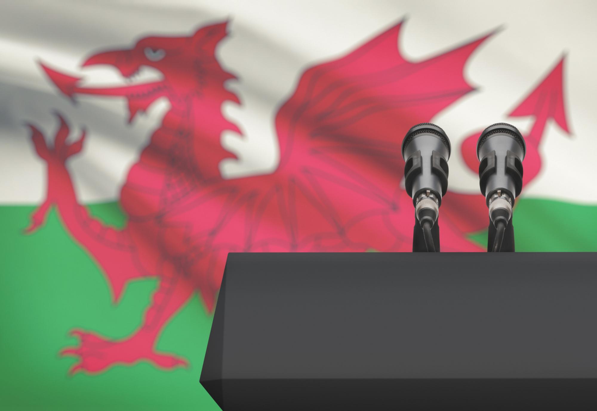 Pulpit and two microphones with a flag on background - Wales