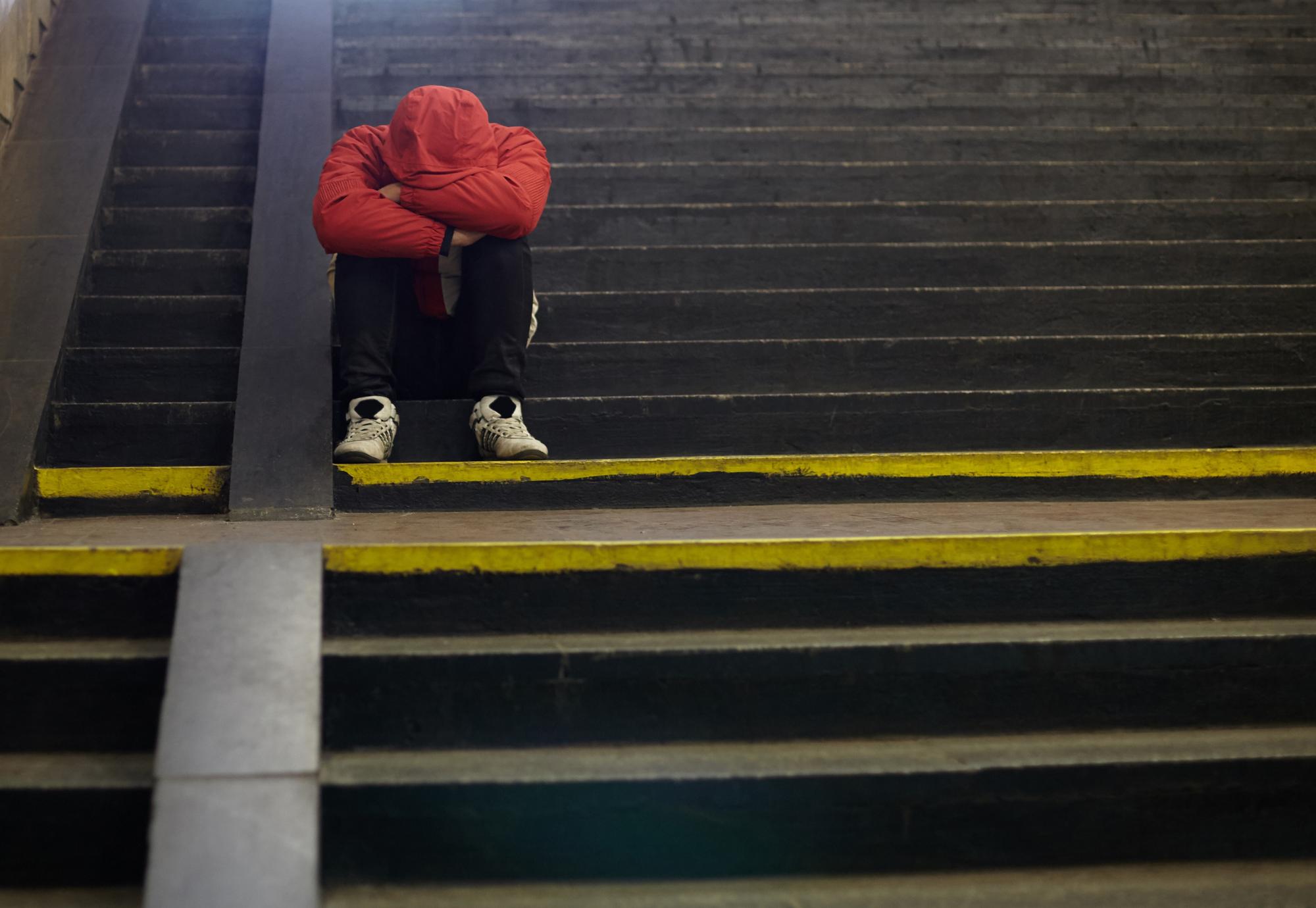 young homeless man sleeping on the street