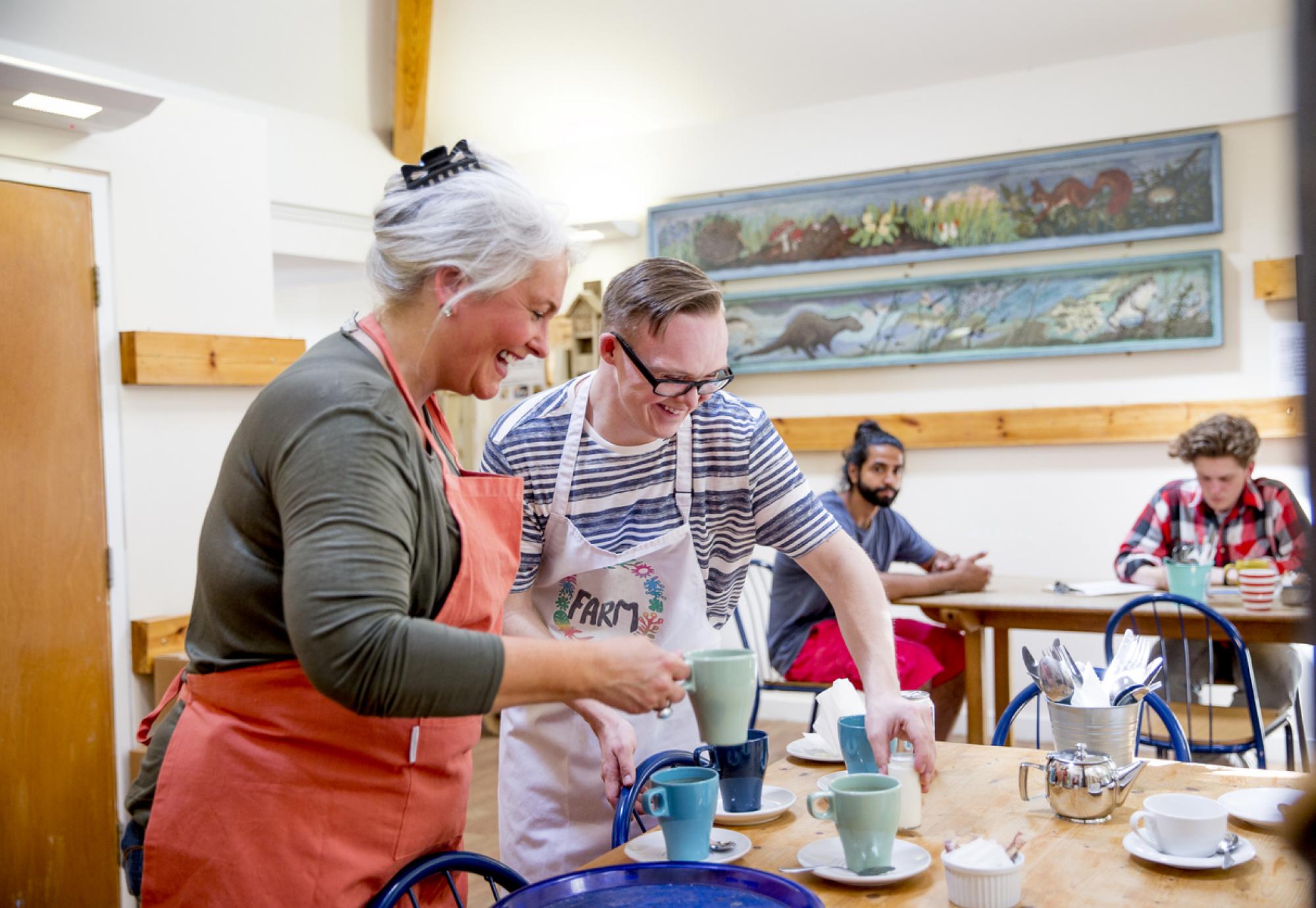 A man and woman prepare hot drinks in the local farm cafe.