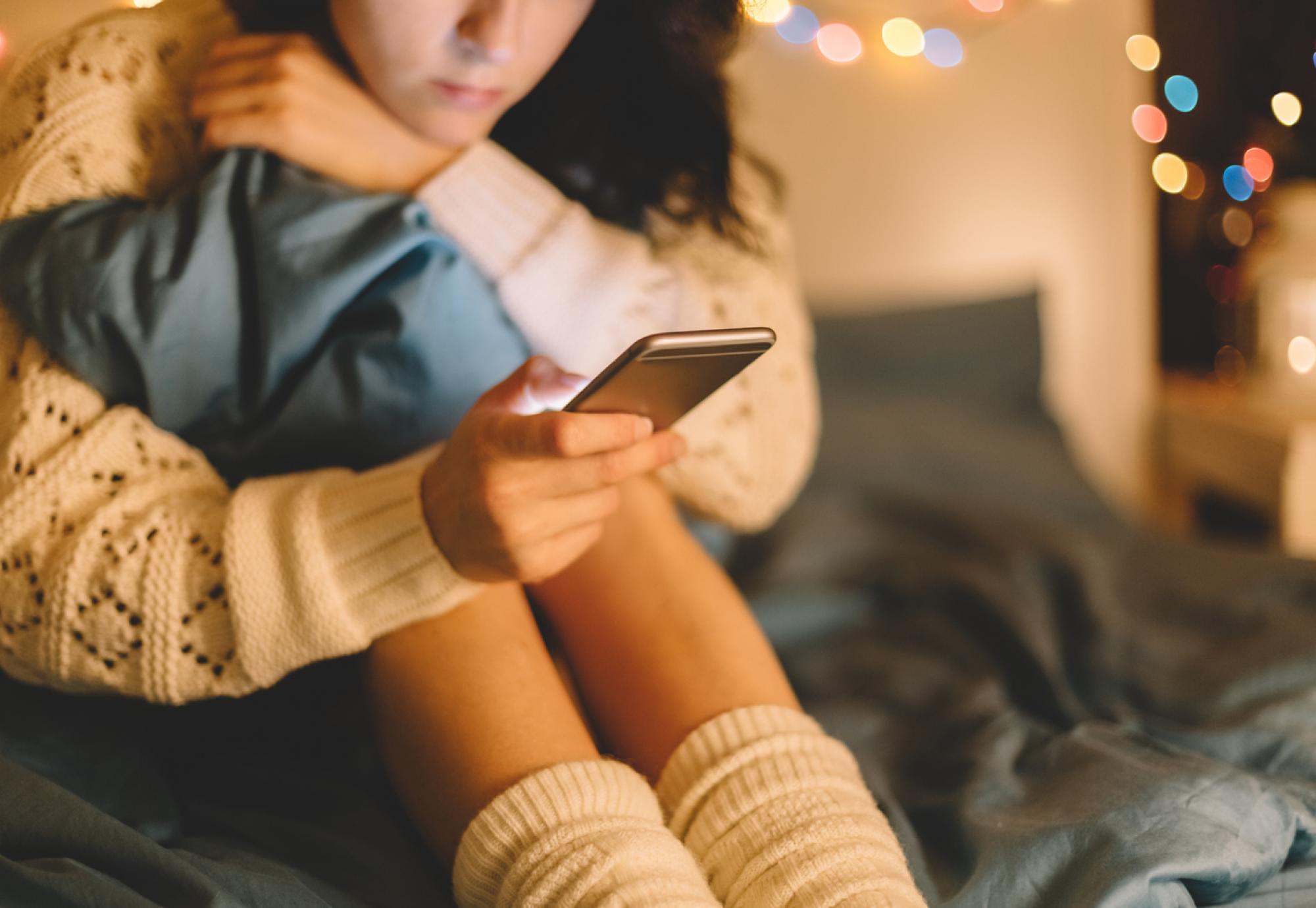 Girl texting on smartphone at home