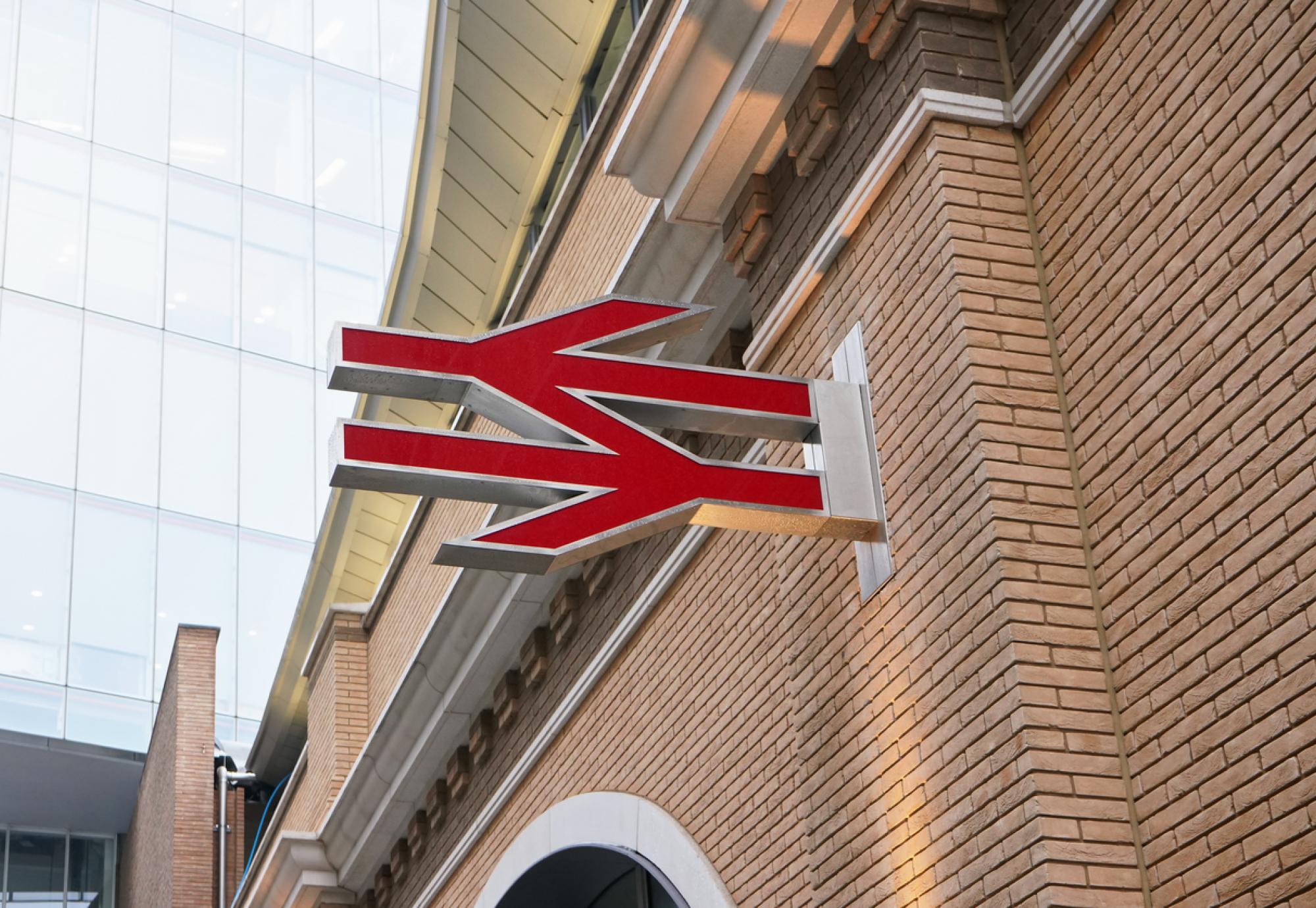 Red British railway logo on orange brick wall