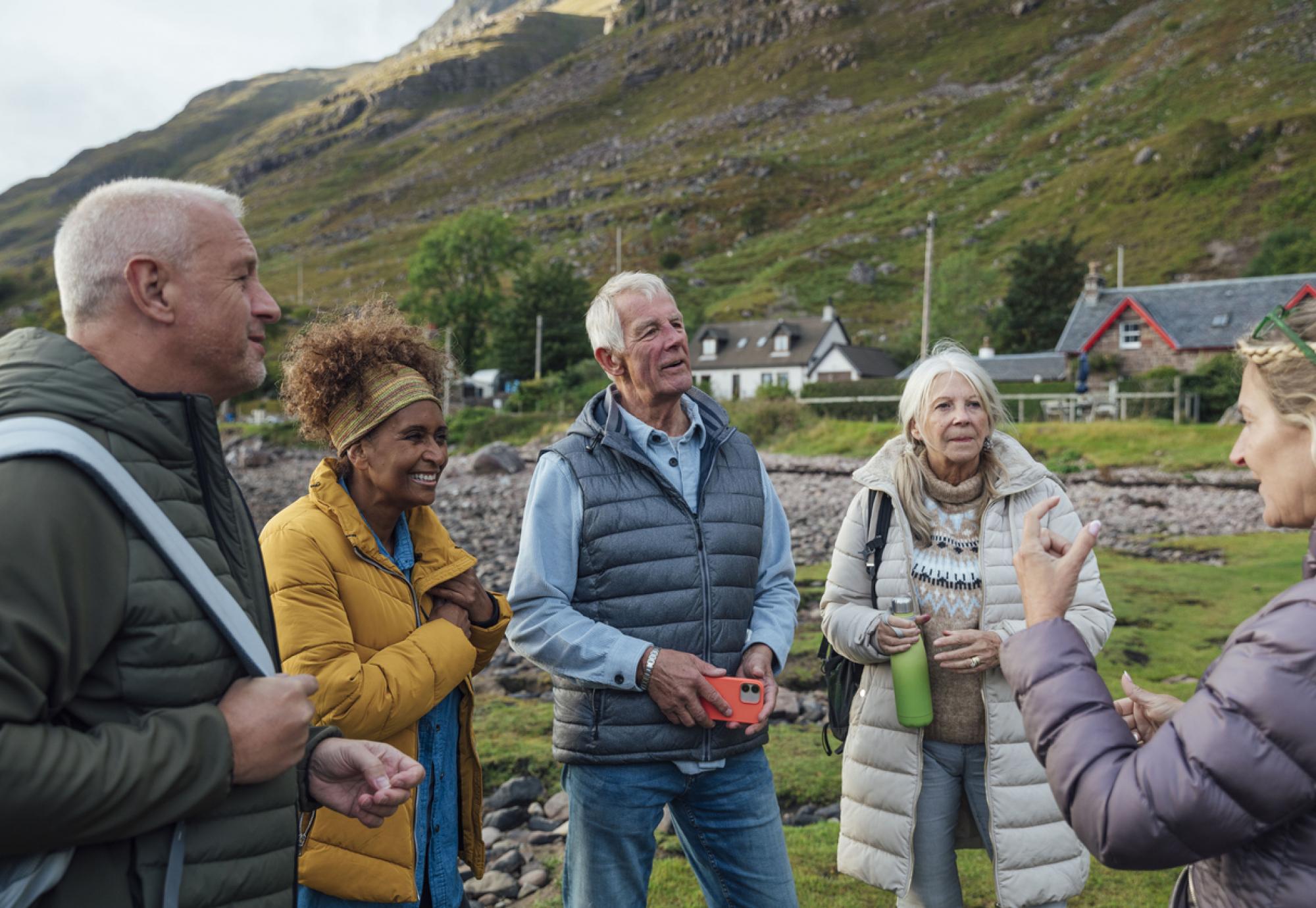 a small group of adults standing on the shore of a sea loch in Torridon, Scotland