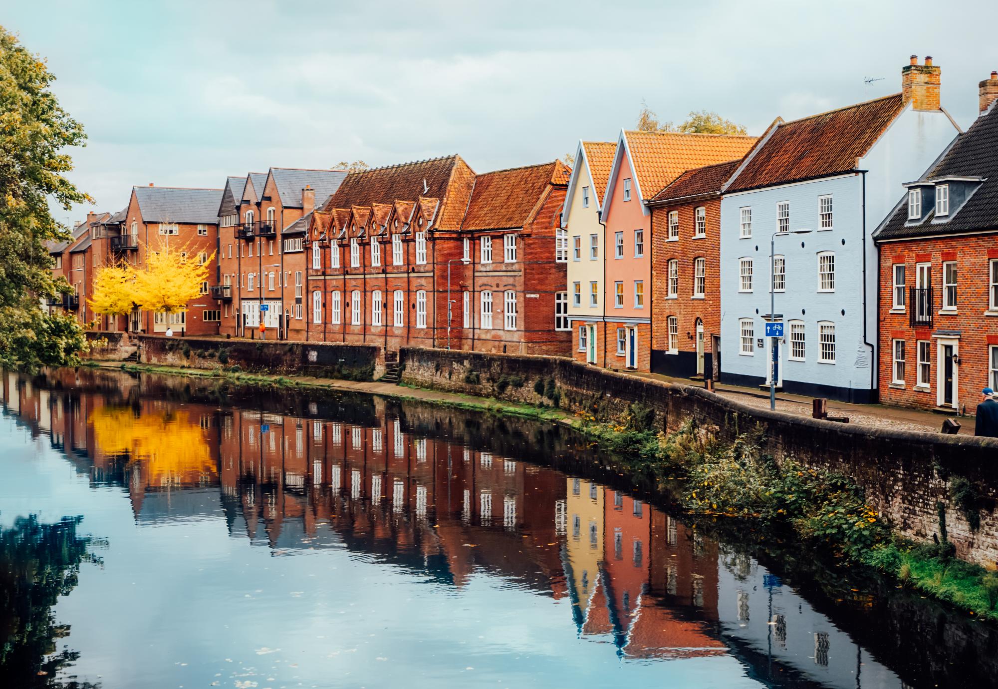 Street view with colorful brick houses near river in the english town of Norwich, England
