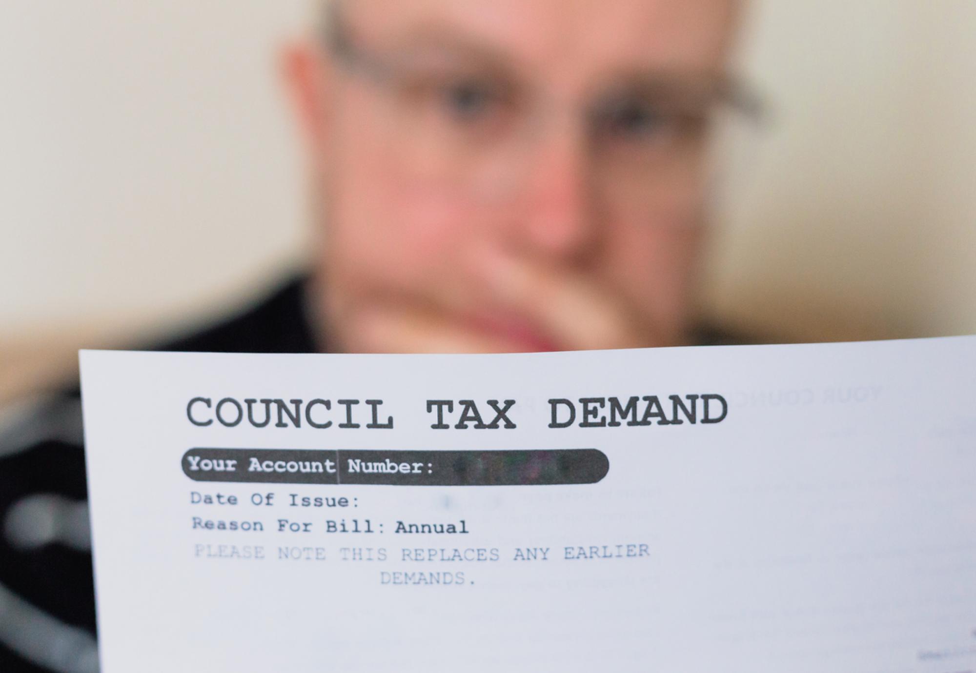 Worried man checking council tax bill