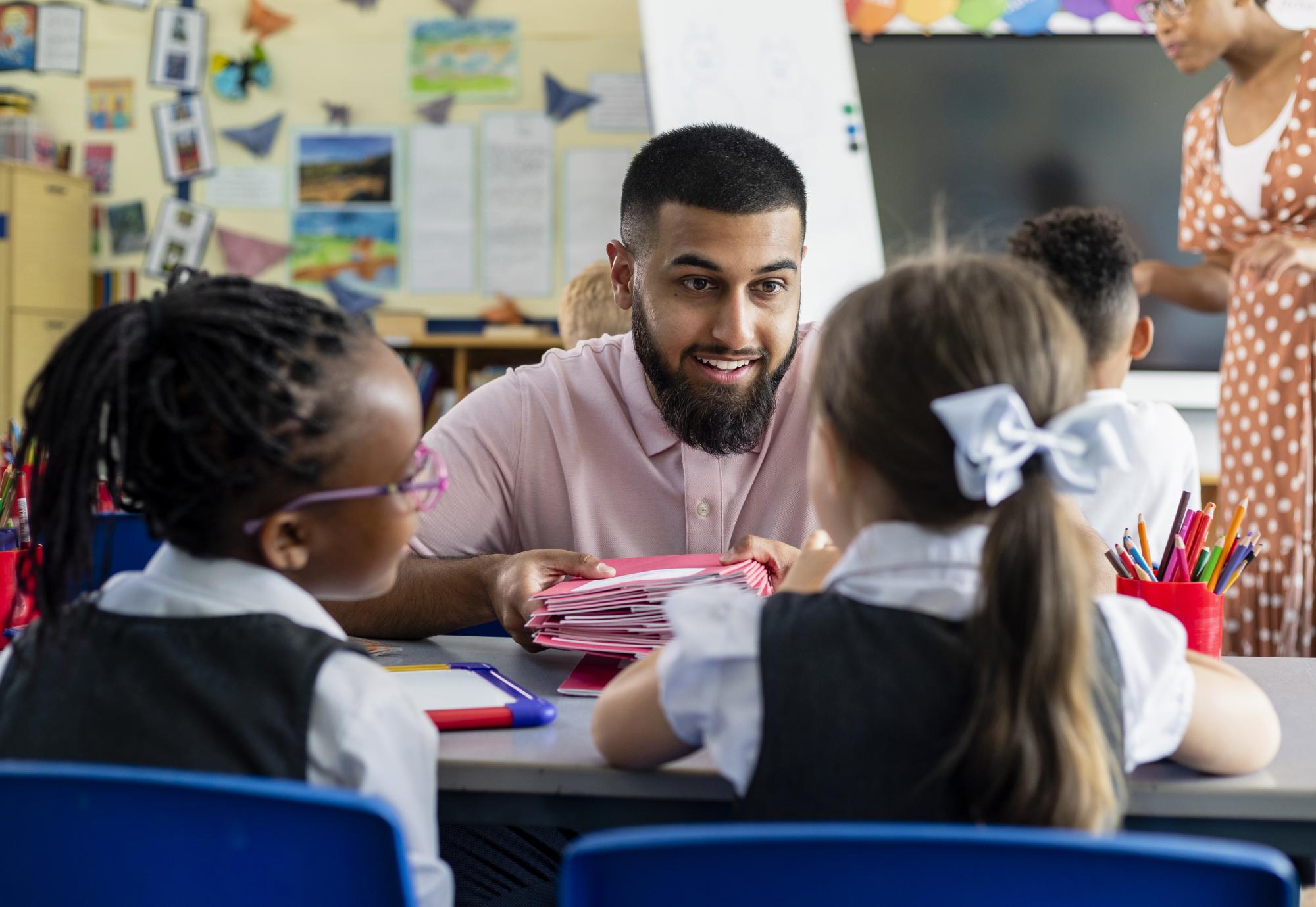 A teacher working with two primary school students