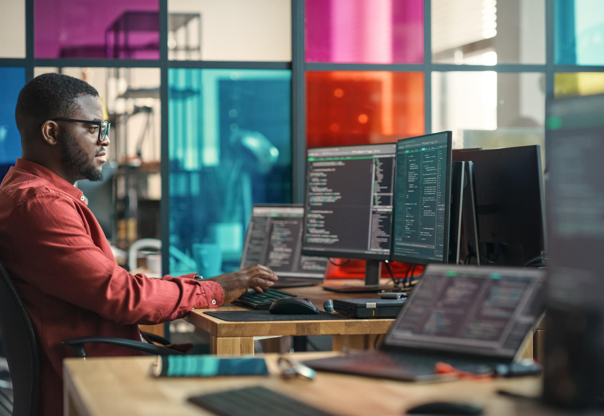 Man writing lines of code on a computer