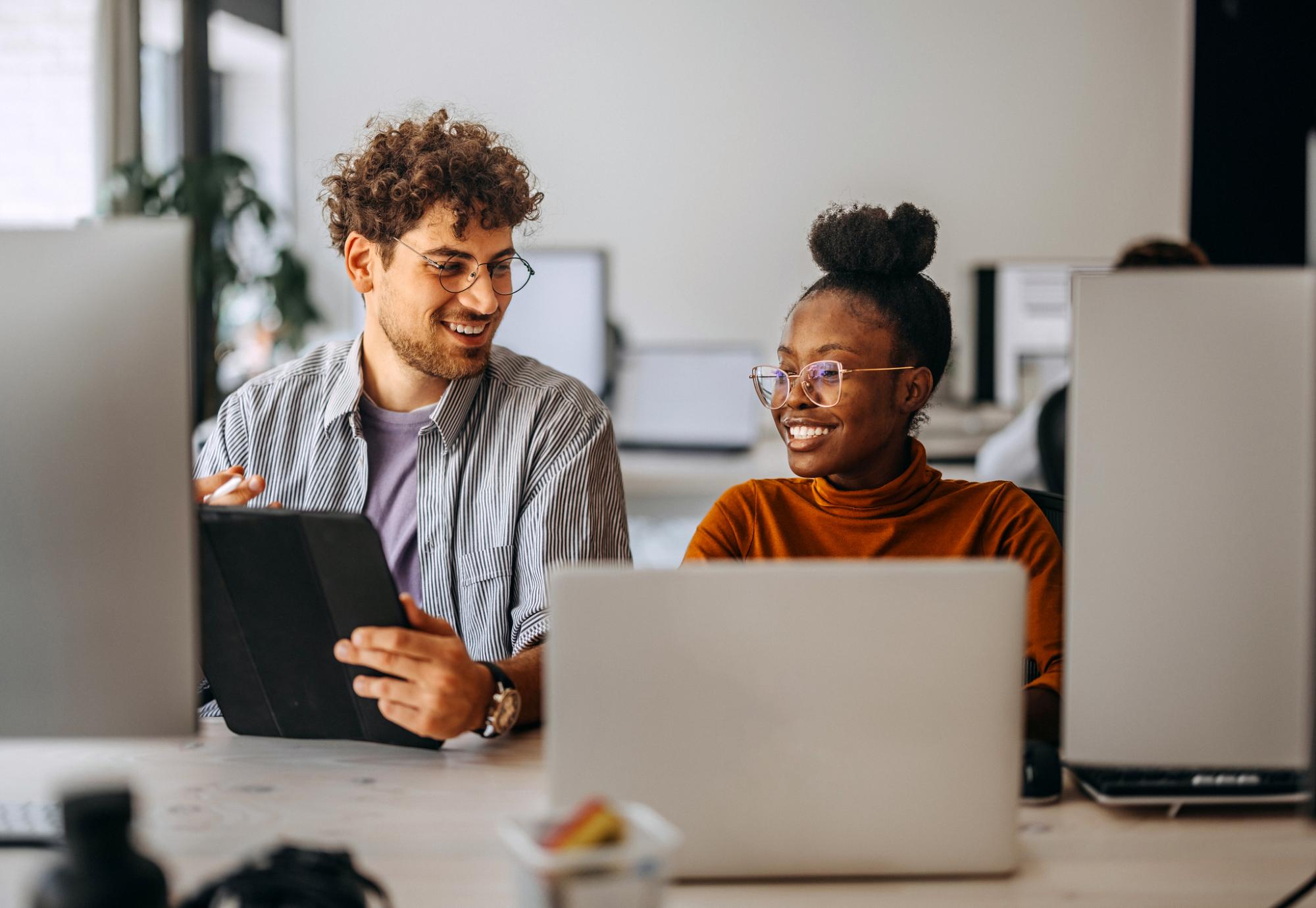Two young colleagues working together at modern office