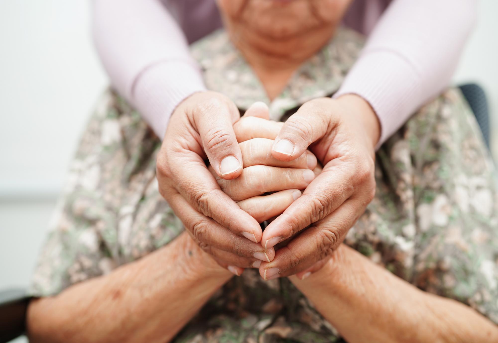 Carer holding hands with patient