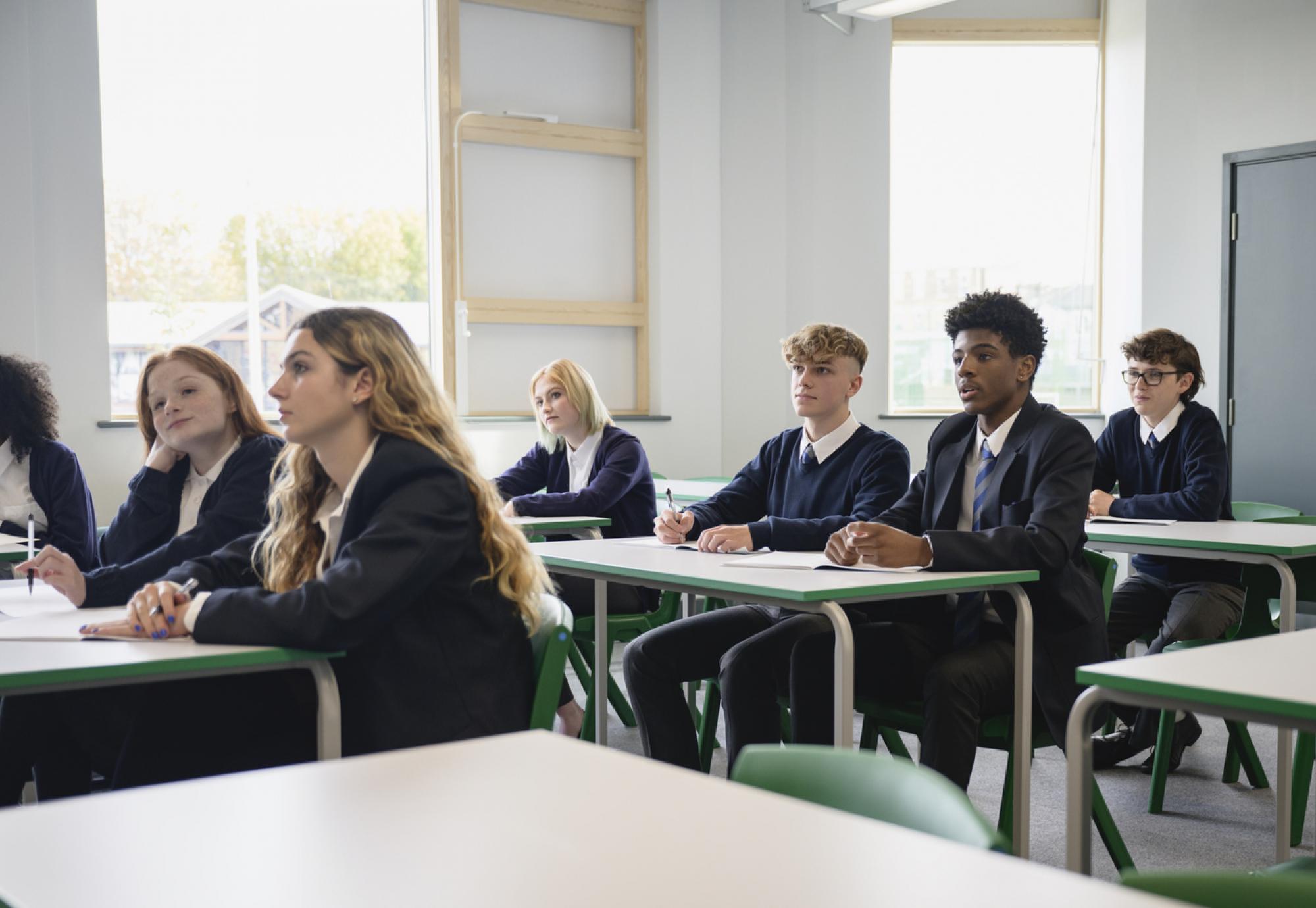 Male and female teenagers in secondary classroom