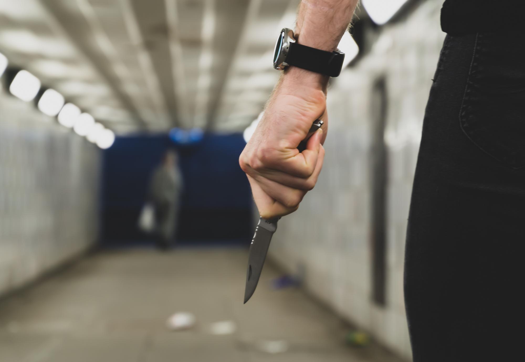 Person in an underpass holding a knife