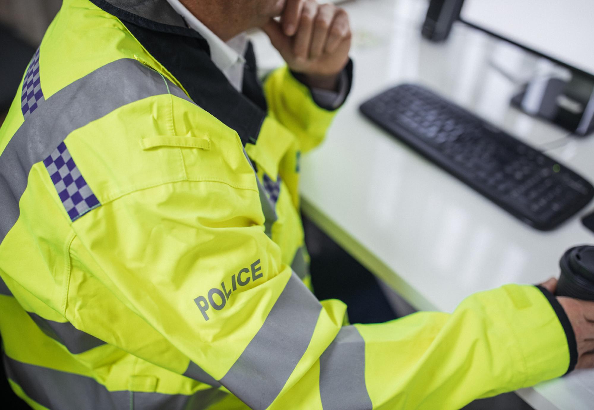 Police officer using digital system on a computer