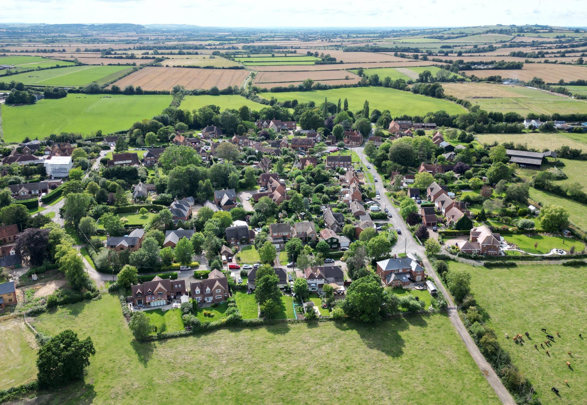 A row of quaint and colourful houses in a lush green field