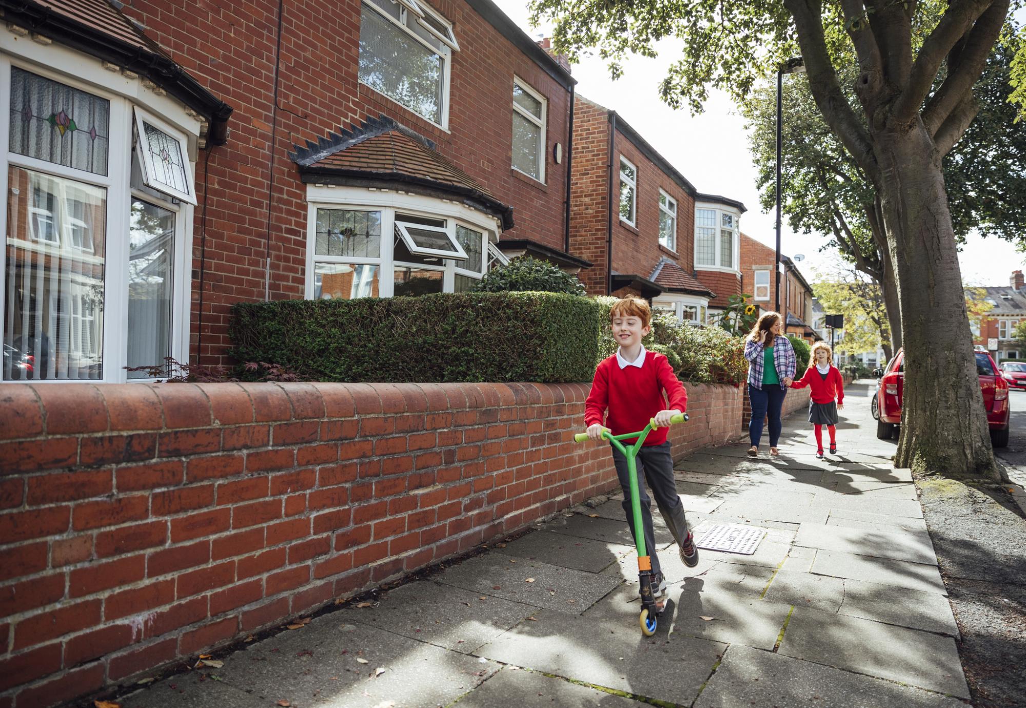 Manchester child using a scooter to get to school