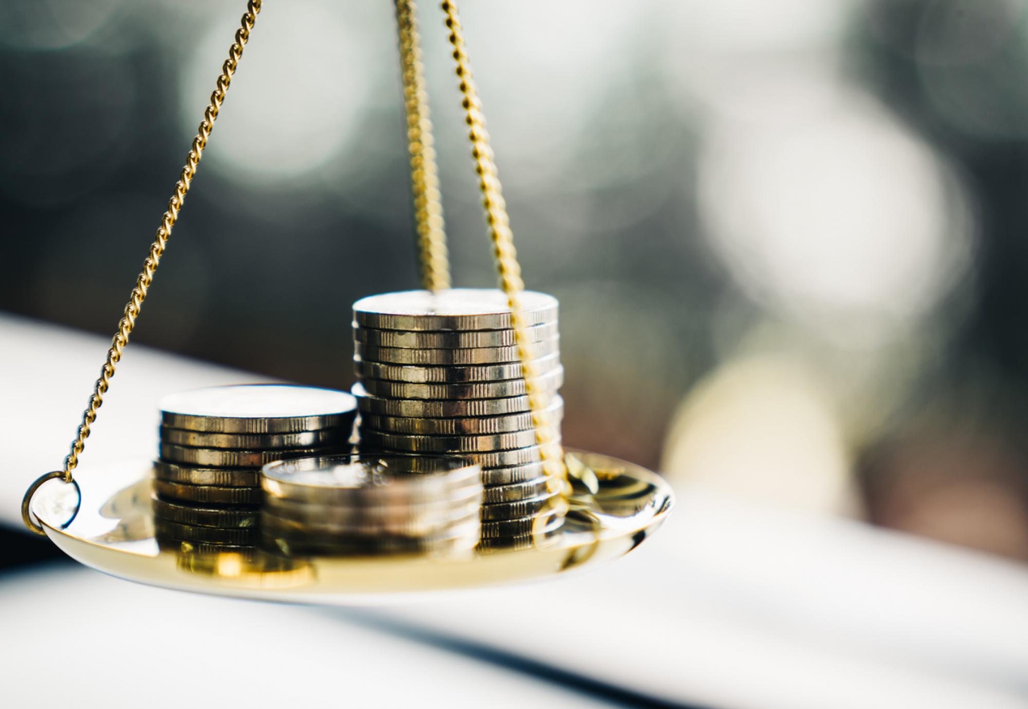 Stack of coins balancing on a scale